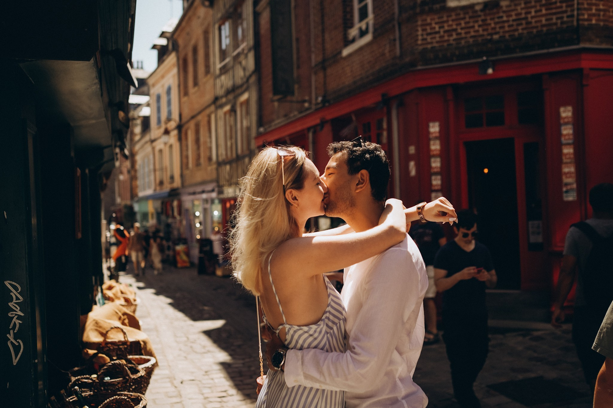 Портрет влюбленной пары целующихся в городской суете европейской улочки