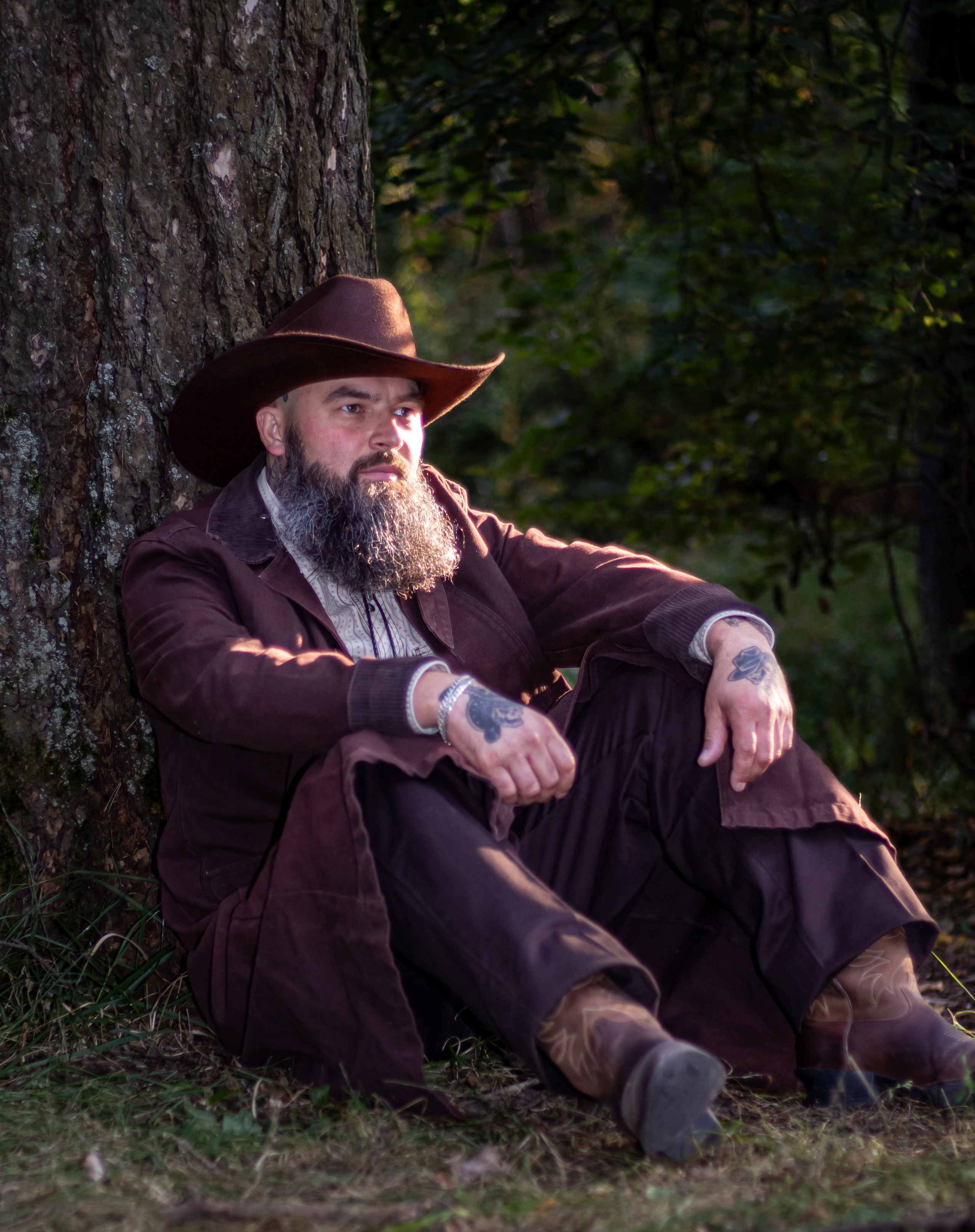 Расслабленный мужской портрет, сидя у дерева — лес