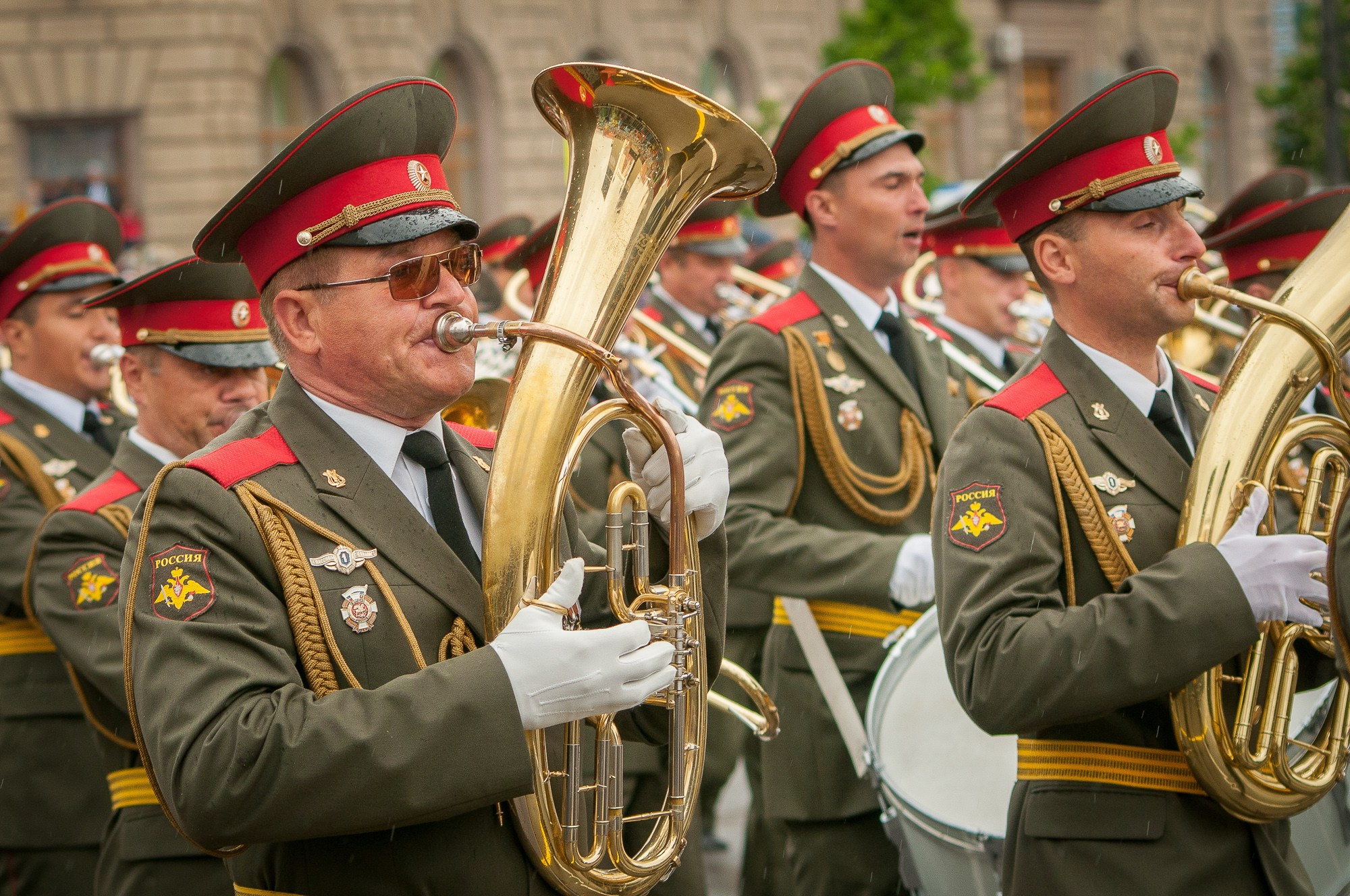 Участники военного оркестра играют на духовых инструментах