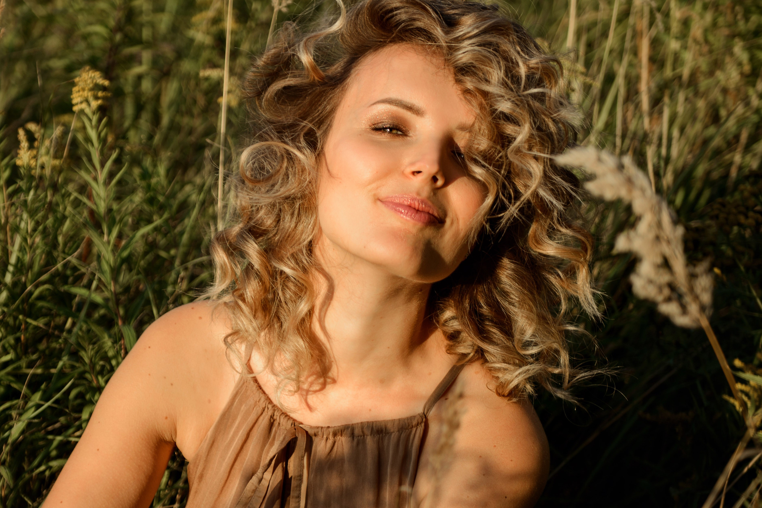 A photo shoot for a woman l in the field. Sunset photo shoot for a girl Curly hair style. (photographer in Edinburgh Elena)