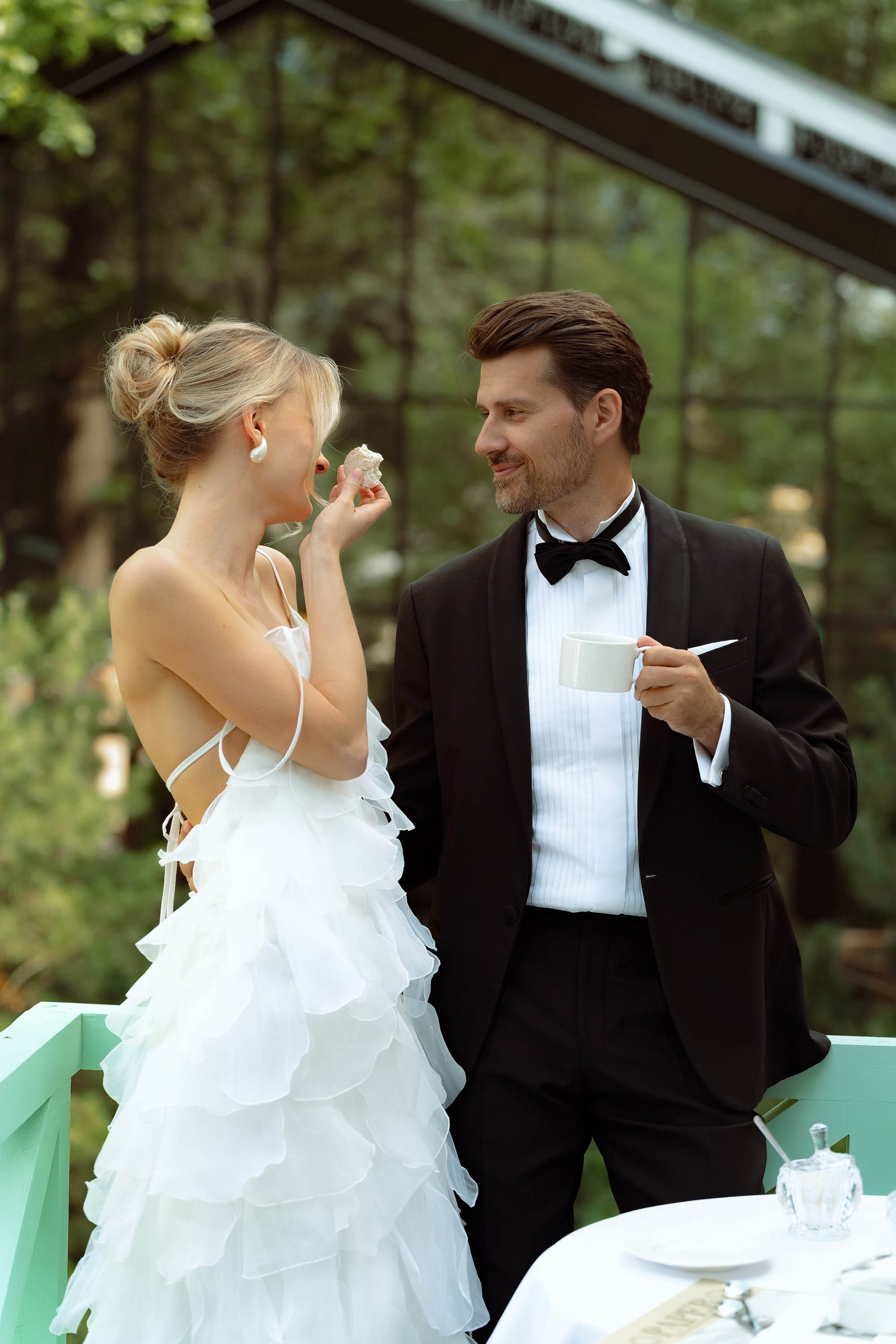 Молодожёны смеются в зелёном саду ресторана — камерная свадьба в СПб