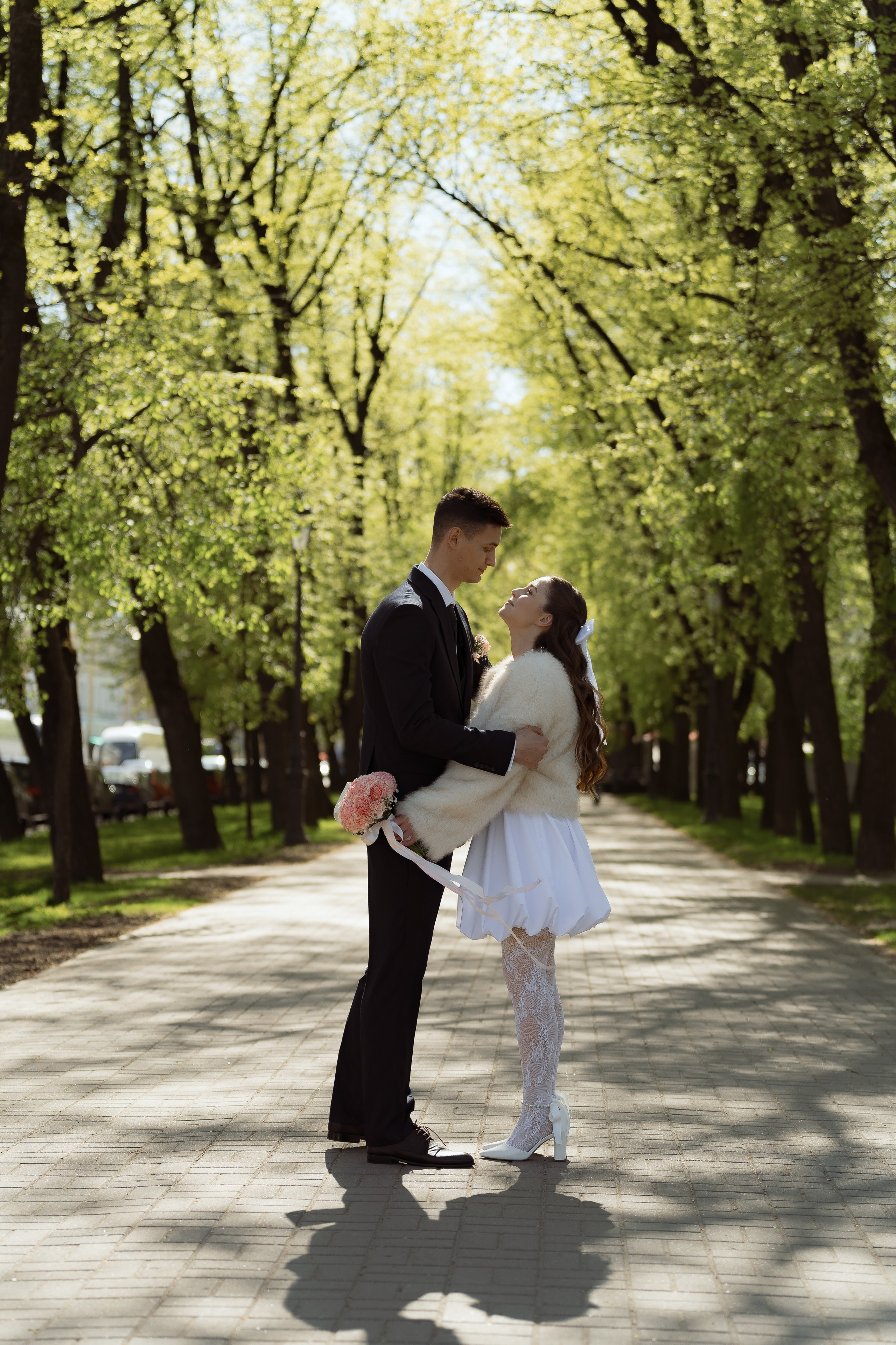 Прогулка пары по аллее в зелени, романтичная весенняя съёмка.