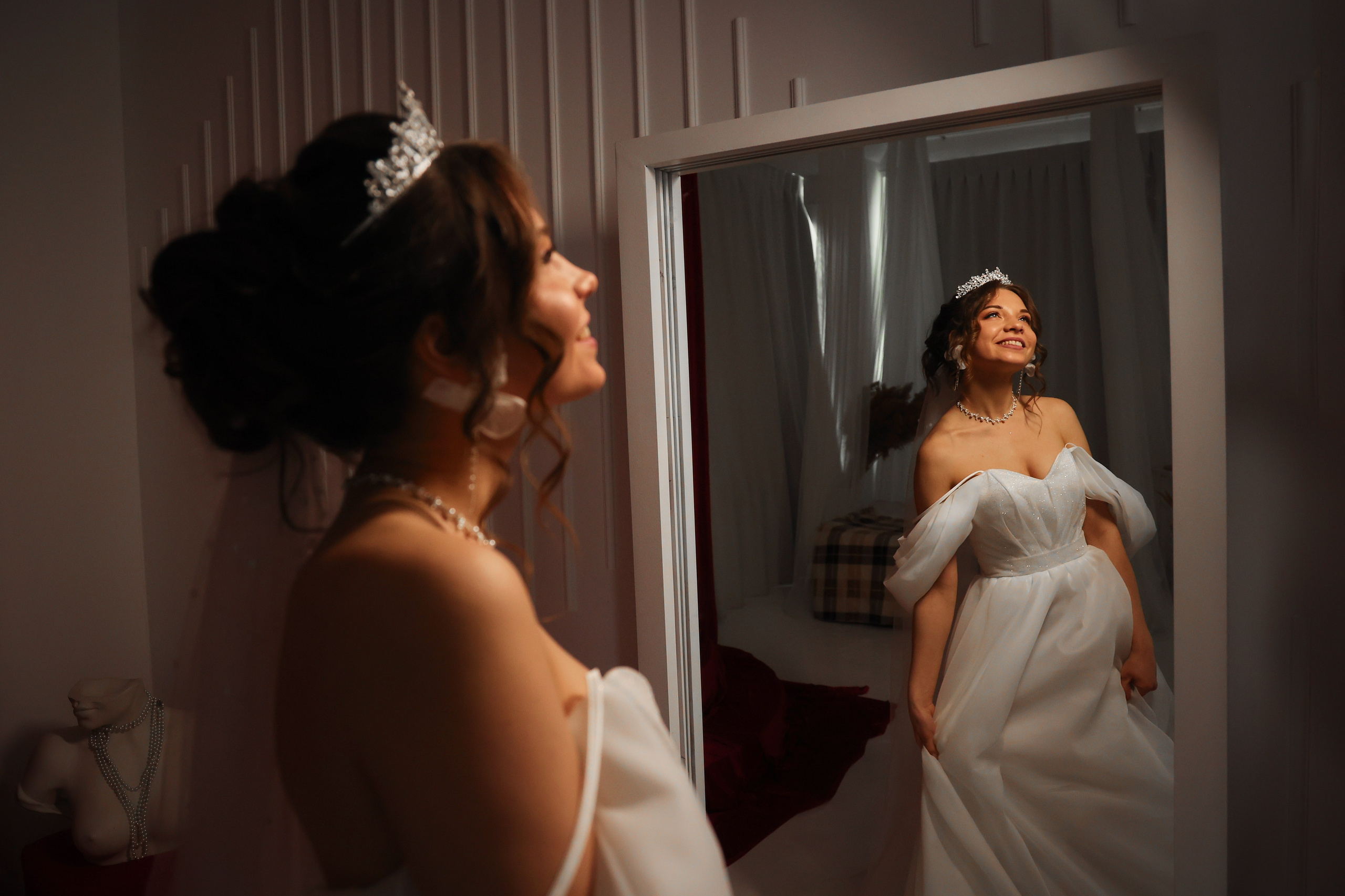 невеста смотрит в зеркало в фотостудии