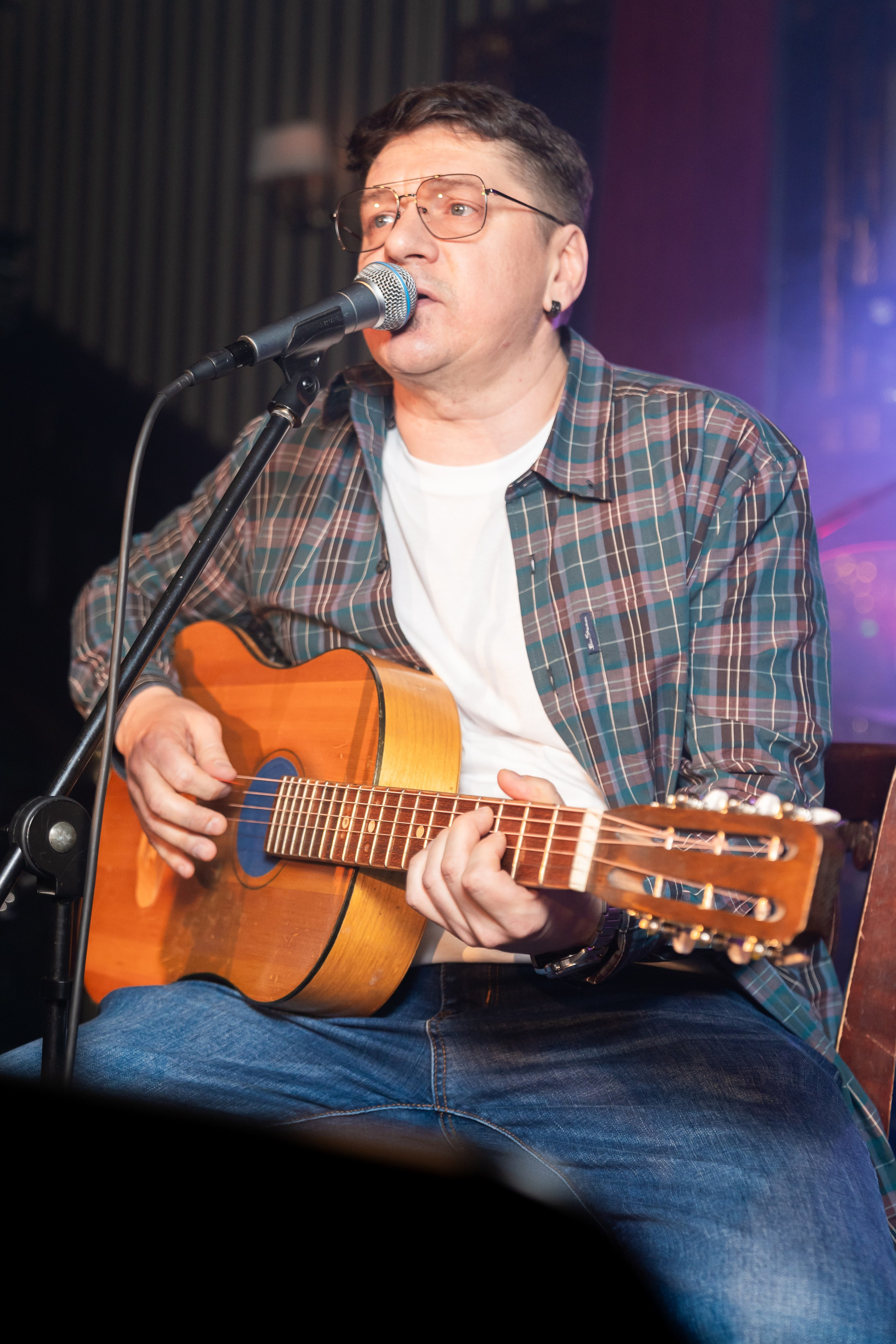 Певец на концерте в Дуглас баре СПБ. Василий Васин исполняет песни на сцене под акустическую гитару, фотограф Мальцев Евгений, Санкт-Петербург.