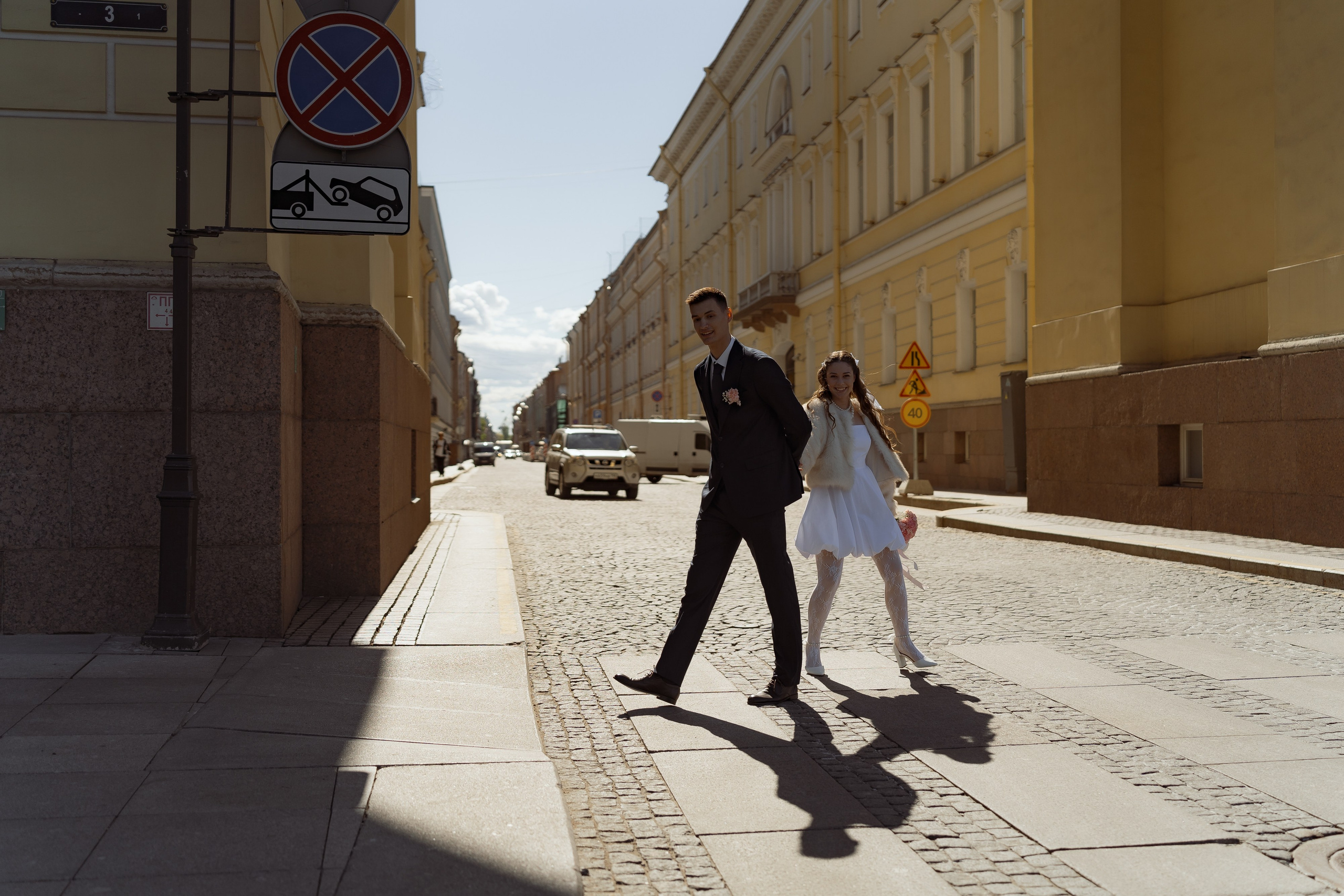 Жених и невеста идут по старинной улице, естественная фотосессия после ЗАГСа