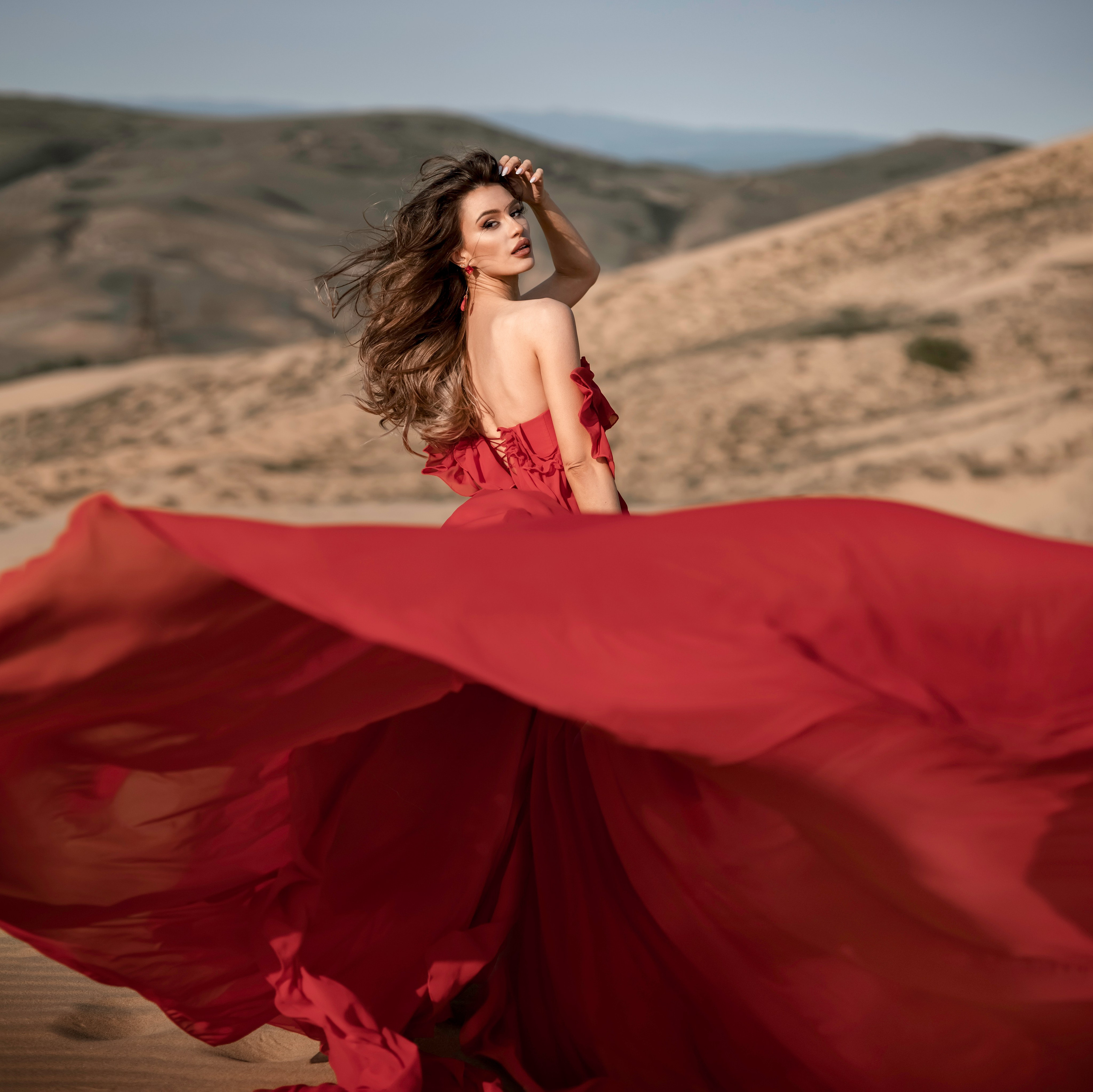 фото девушка в летящем красном платье фотосессия на бархане