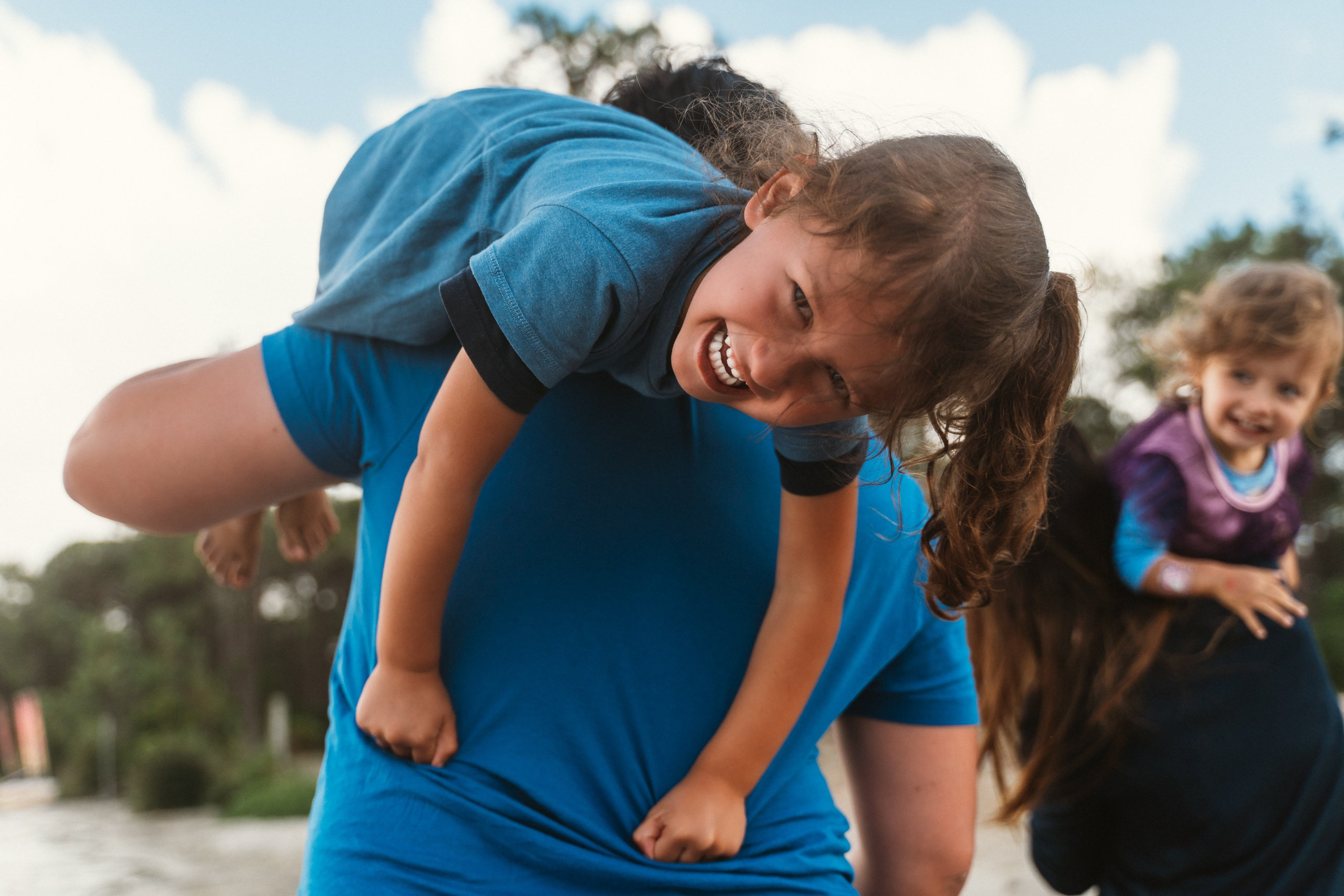 A family of four smiles together against a backdrop of the Tuscany sky.