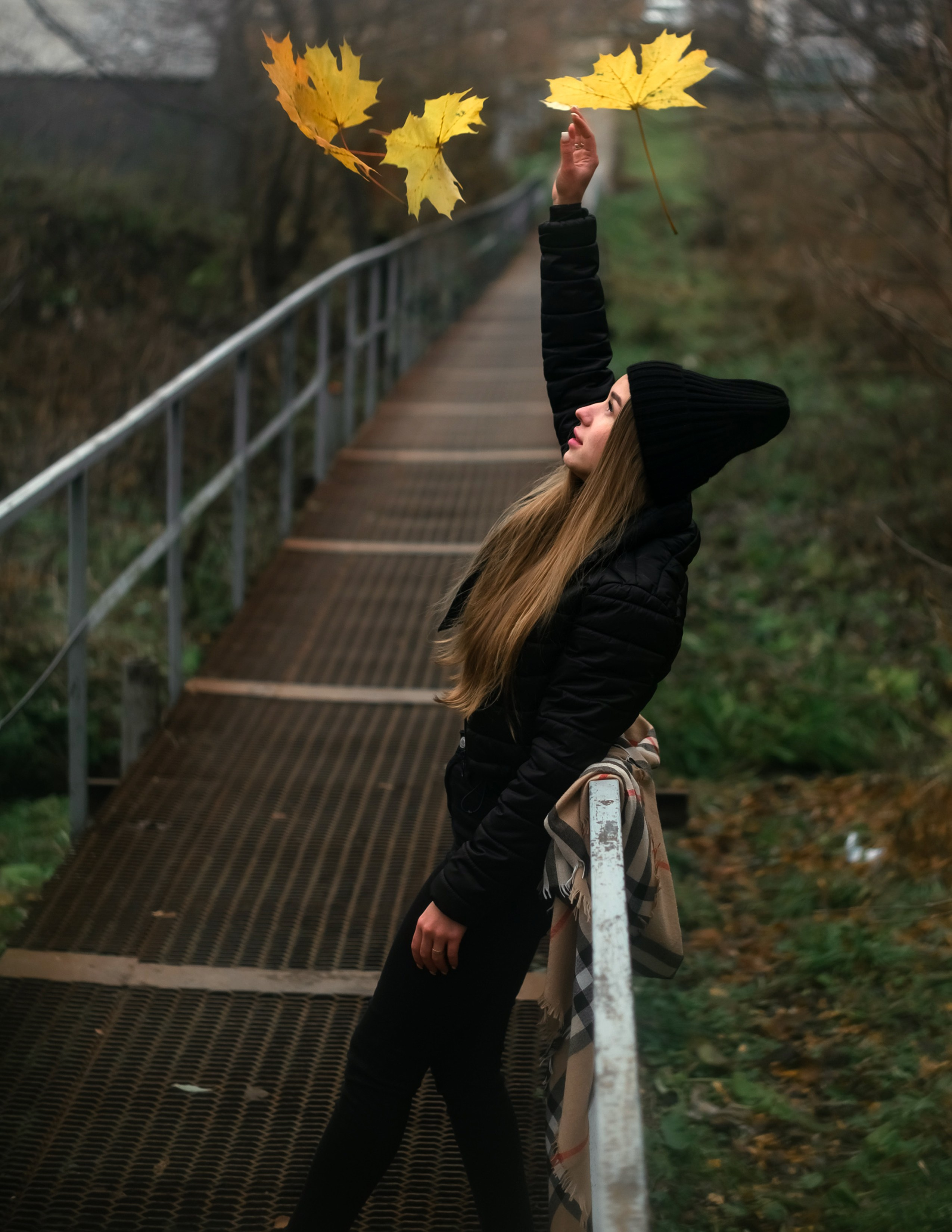 На фото девушки подбрасывает осенние листья.