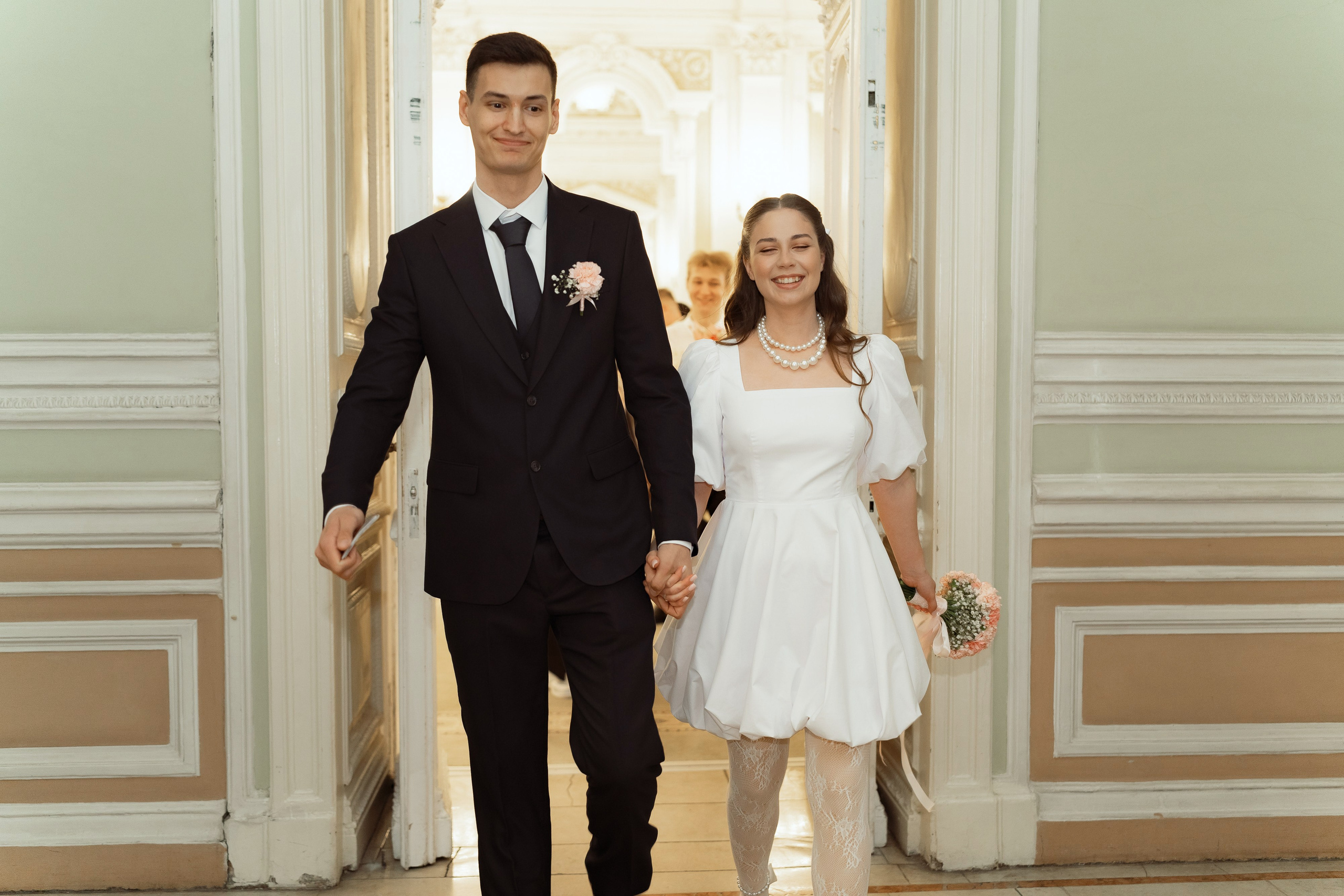 Молодожёны выходят из зала ЗАГСа после церемонии, счастливый момент