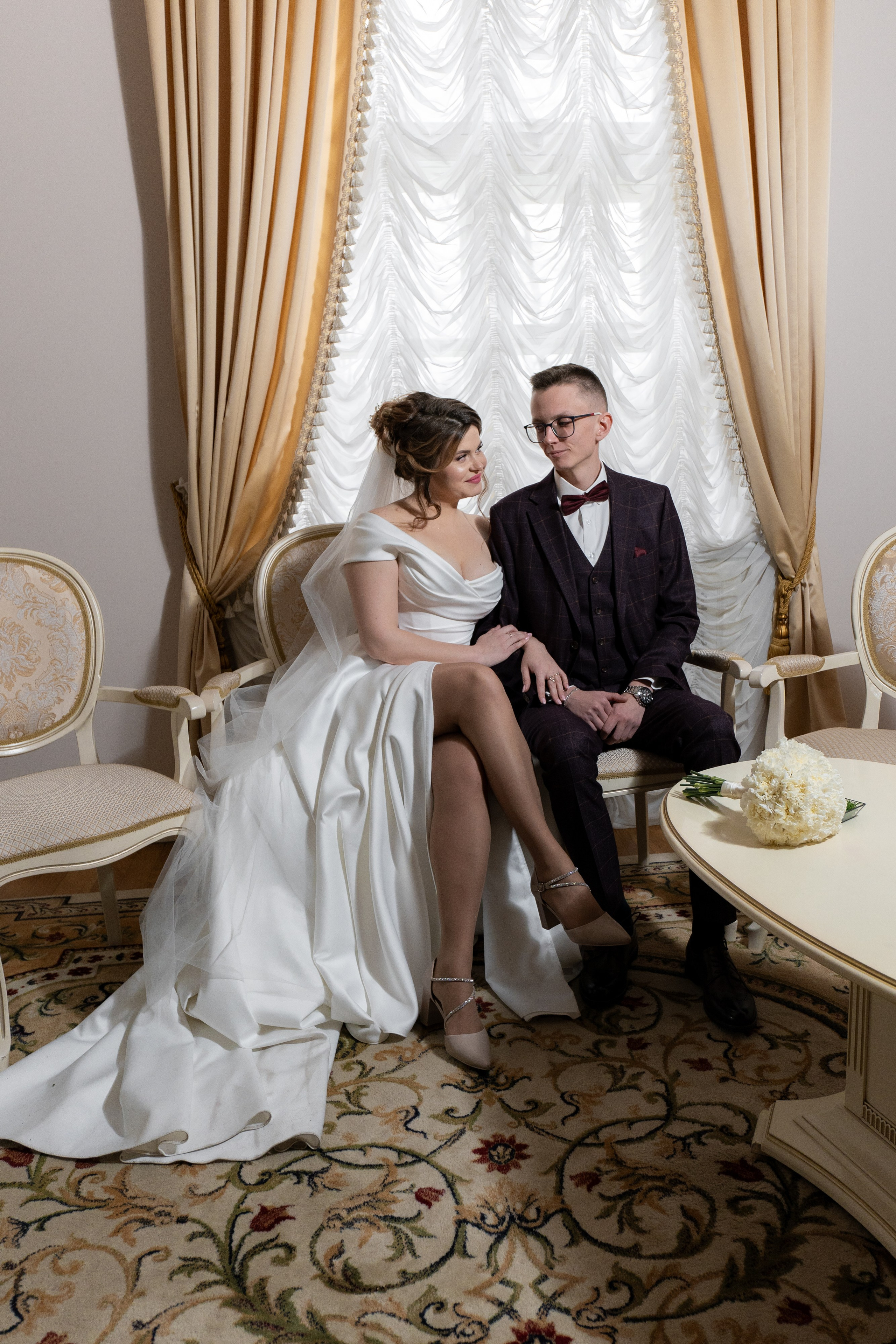 жених обнимает невесту на фотосессии в комнате жениха и невесты в дворце бракосочетания 3 в Царском Селе