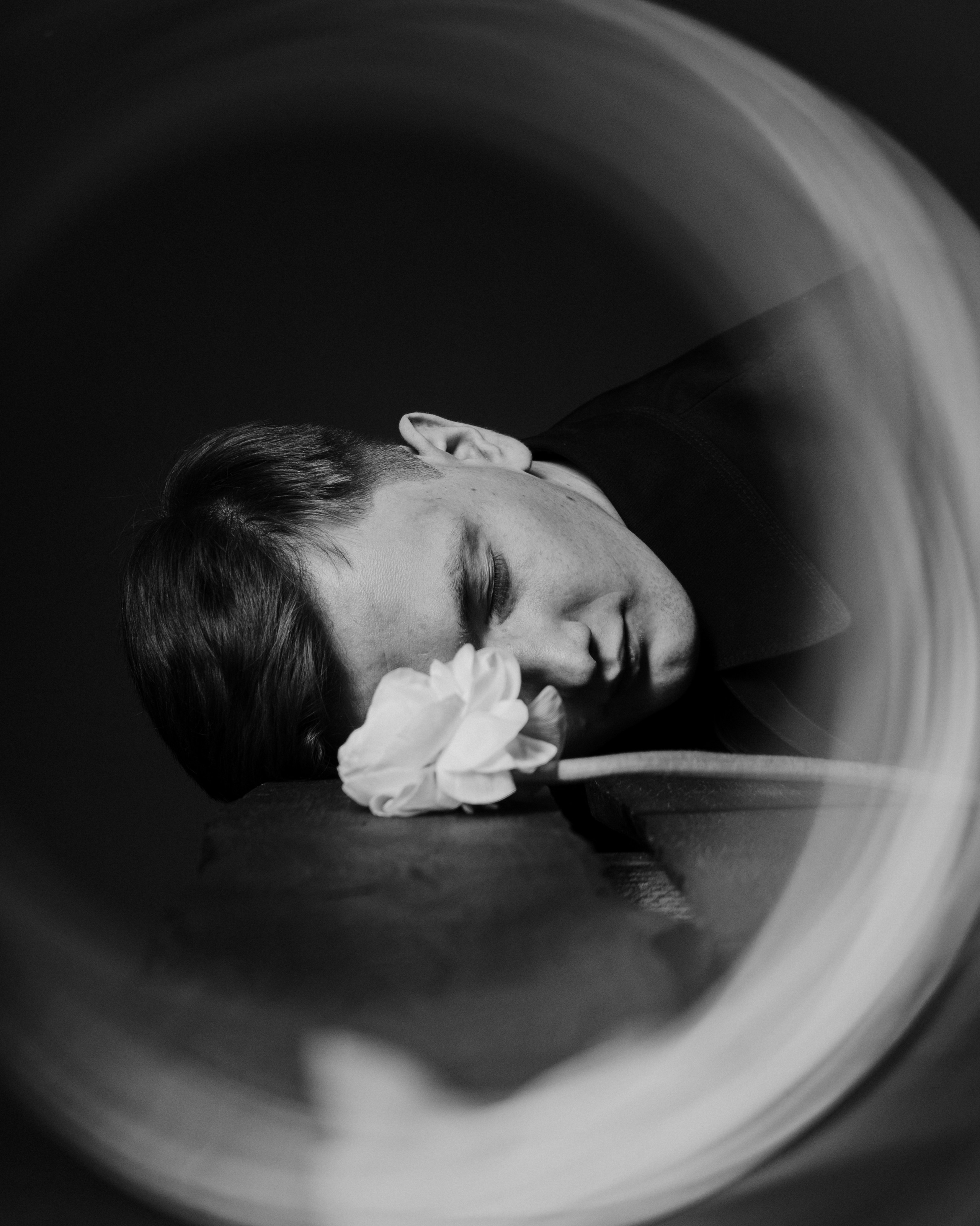 Черно-белый портрет мужчины с цветком в студии