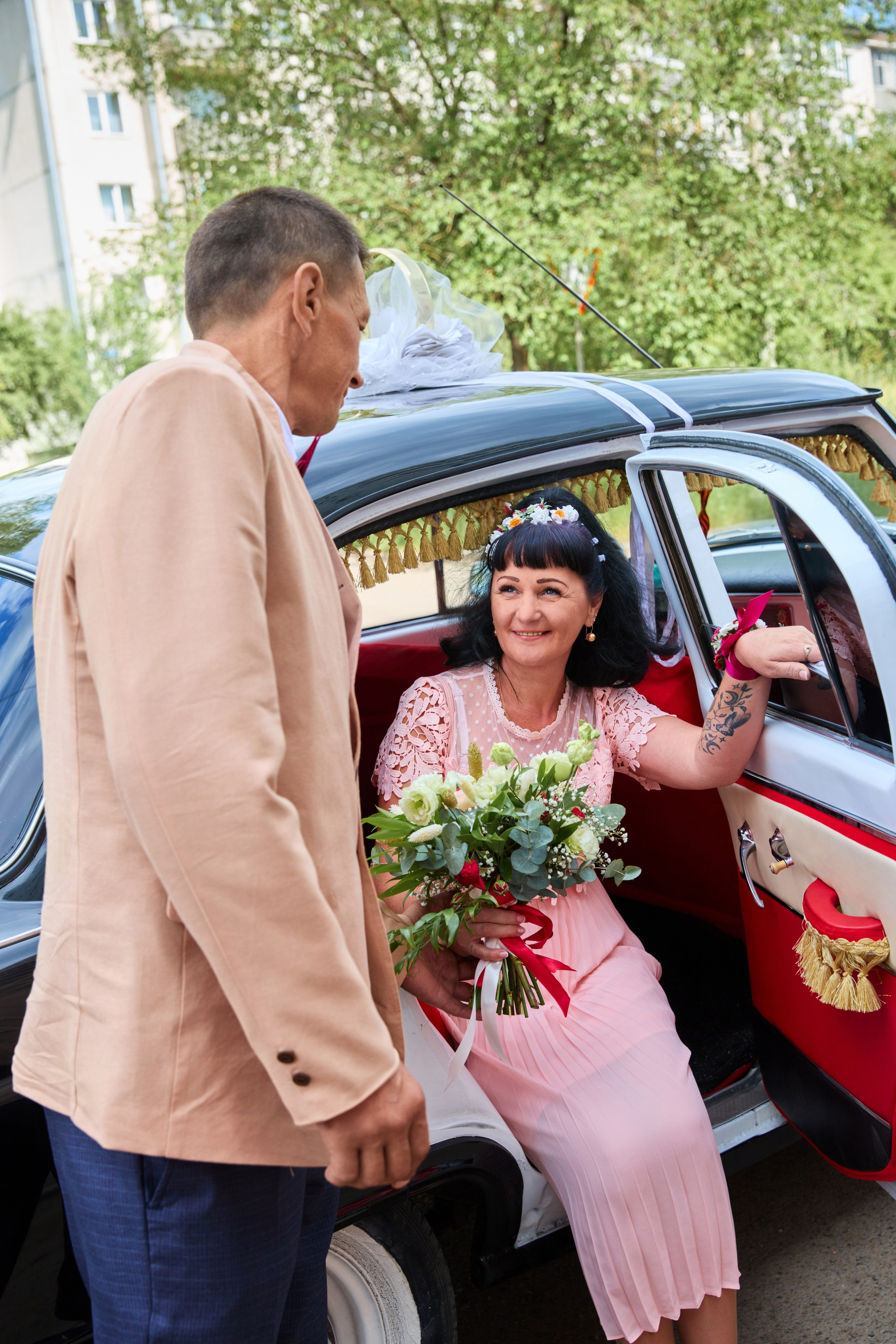 жених помогает выйти из машины невесте
