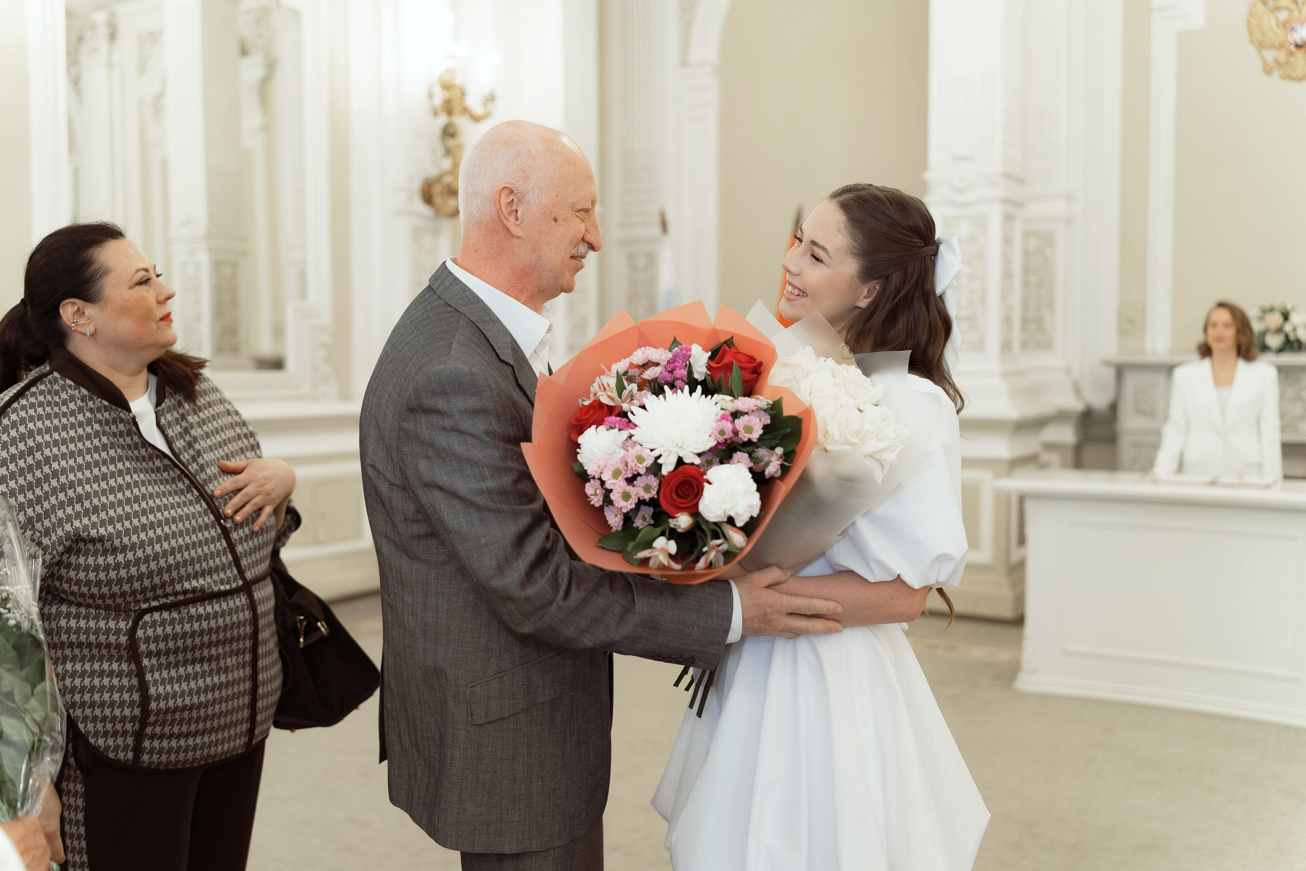 Невеста принимает поздравления и цветы от родственников в ЗАГСе