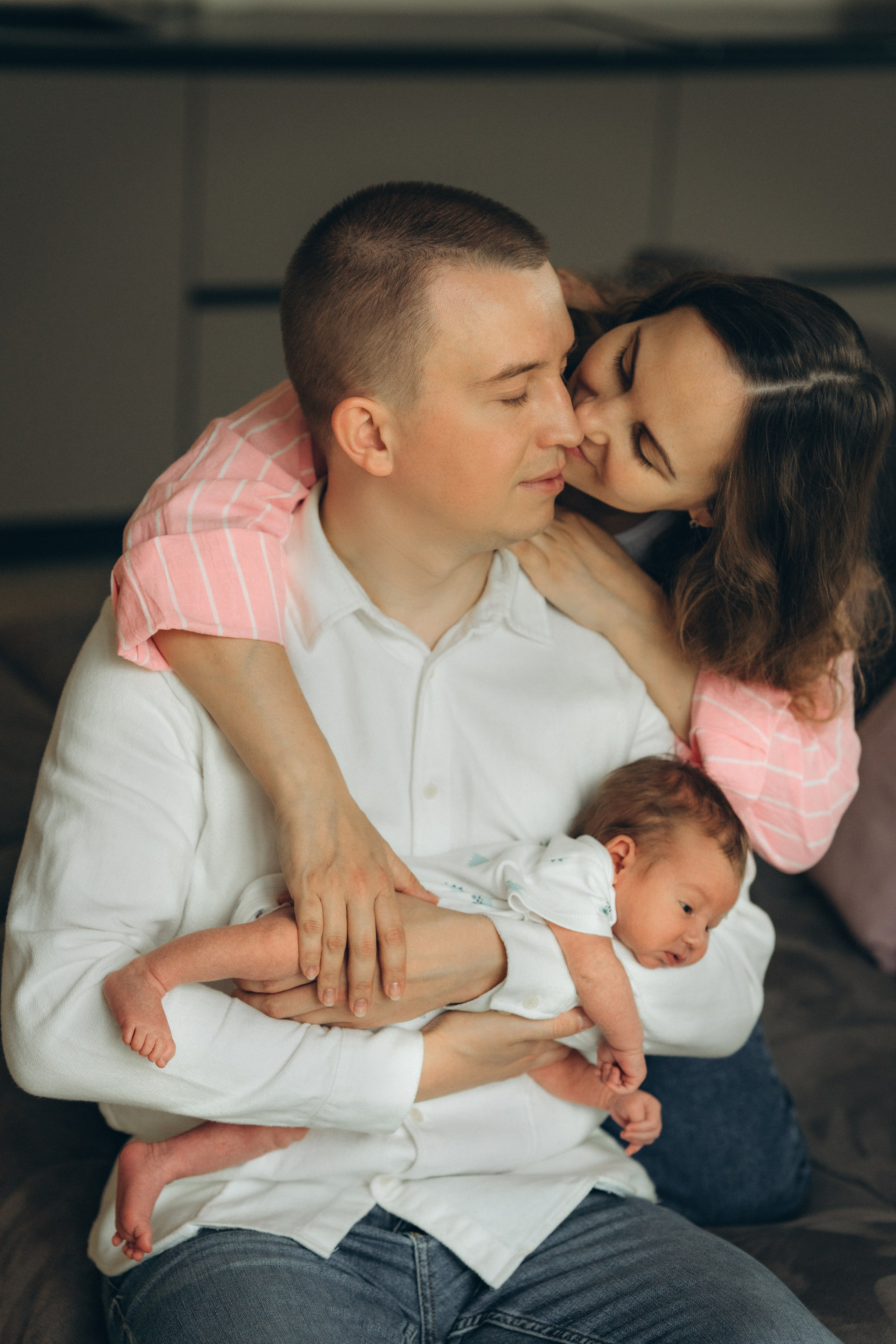 Родители с новорождённым Гришей во время домашней фотосессии