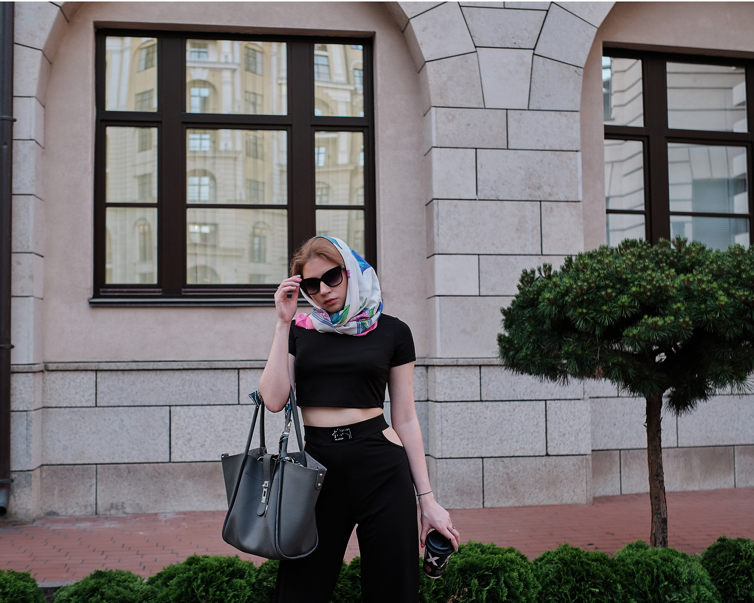 Девушка в очках на фоне дома