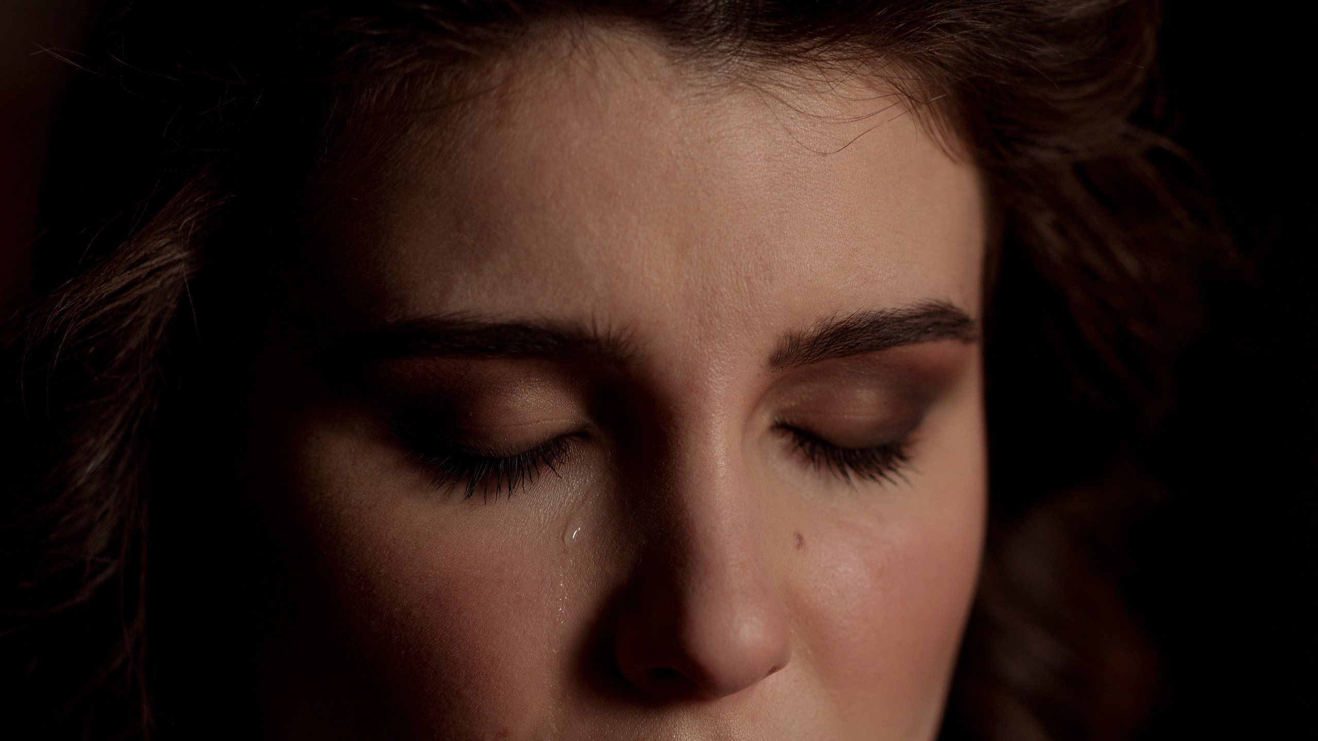 Глаза девушки закрыты, из глаз бегут слёзы