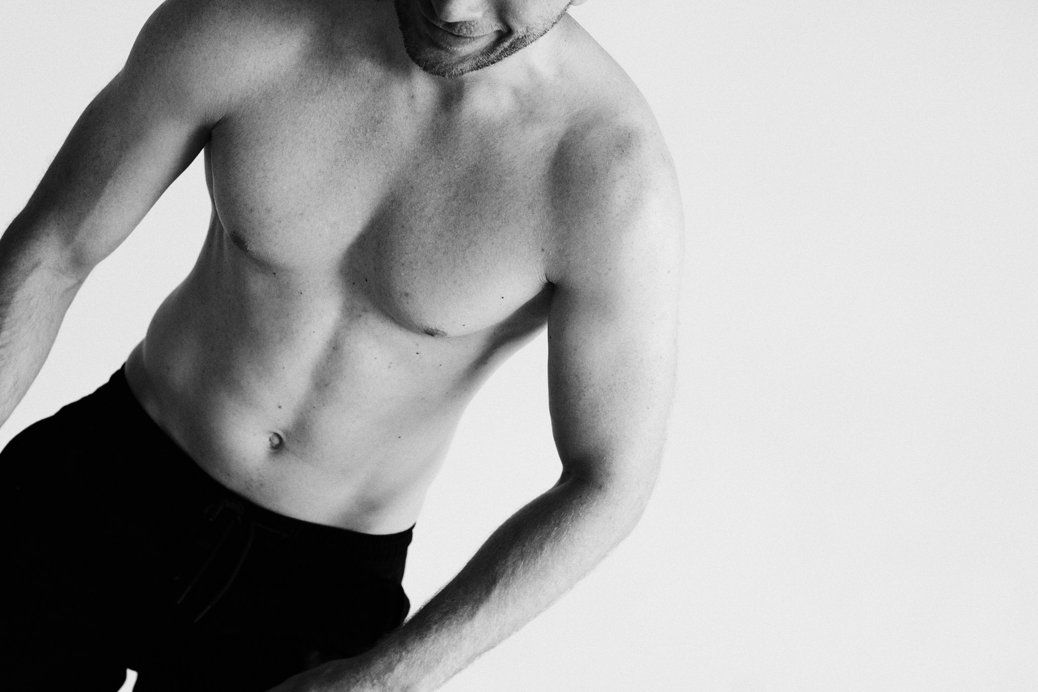 Черно-белое фото мужчины с акцентом на рельеф мышц. Фотограф Дарья Мустафина.