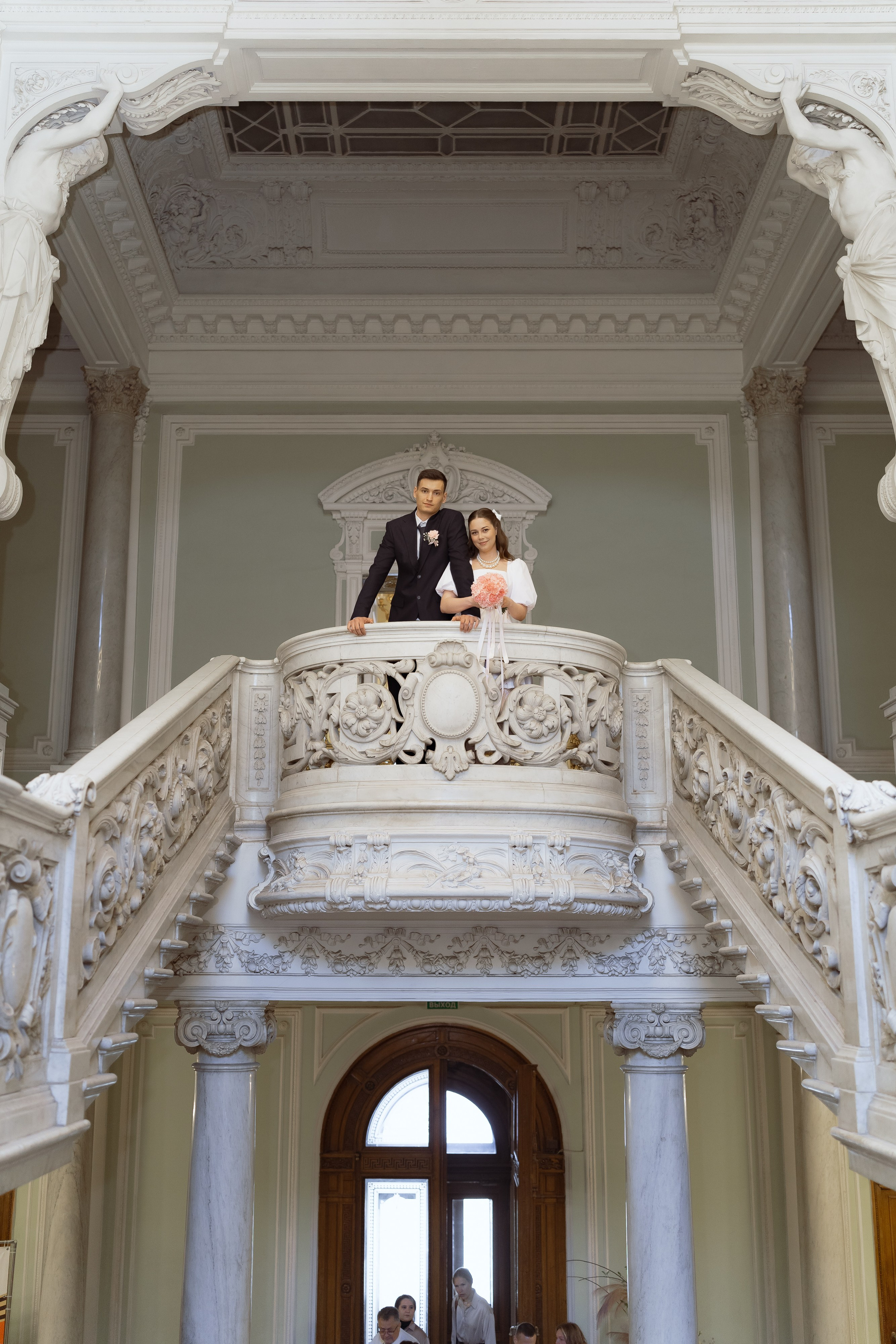 Жених и невеста на балконе старинного ЗАГСа, романтичный свадебный кадр