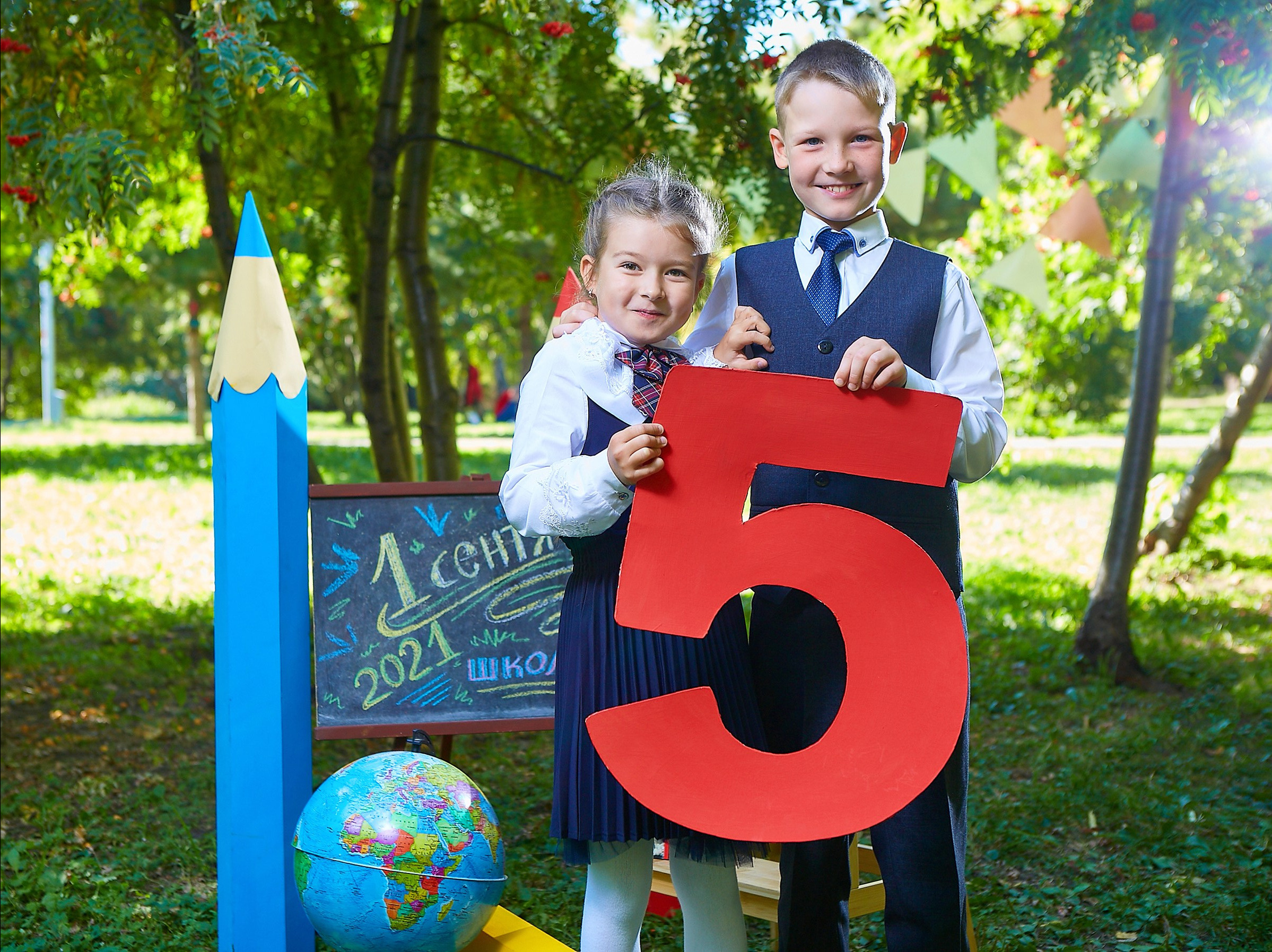 мальчик и девочка держат цифру пять