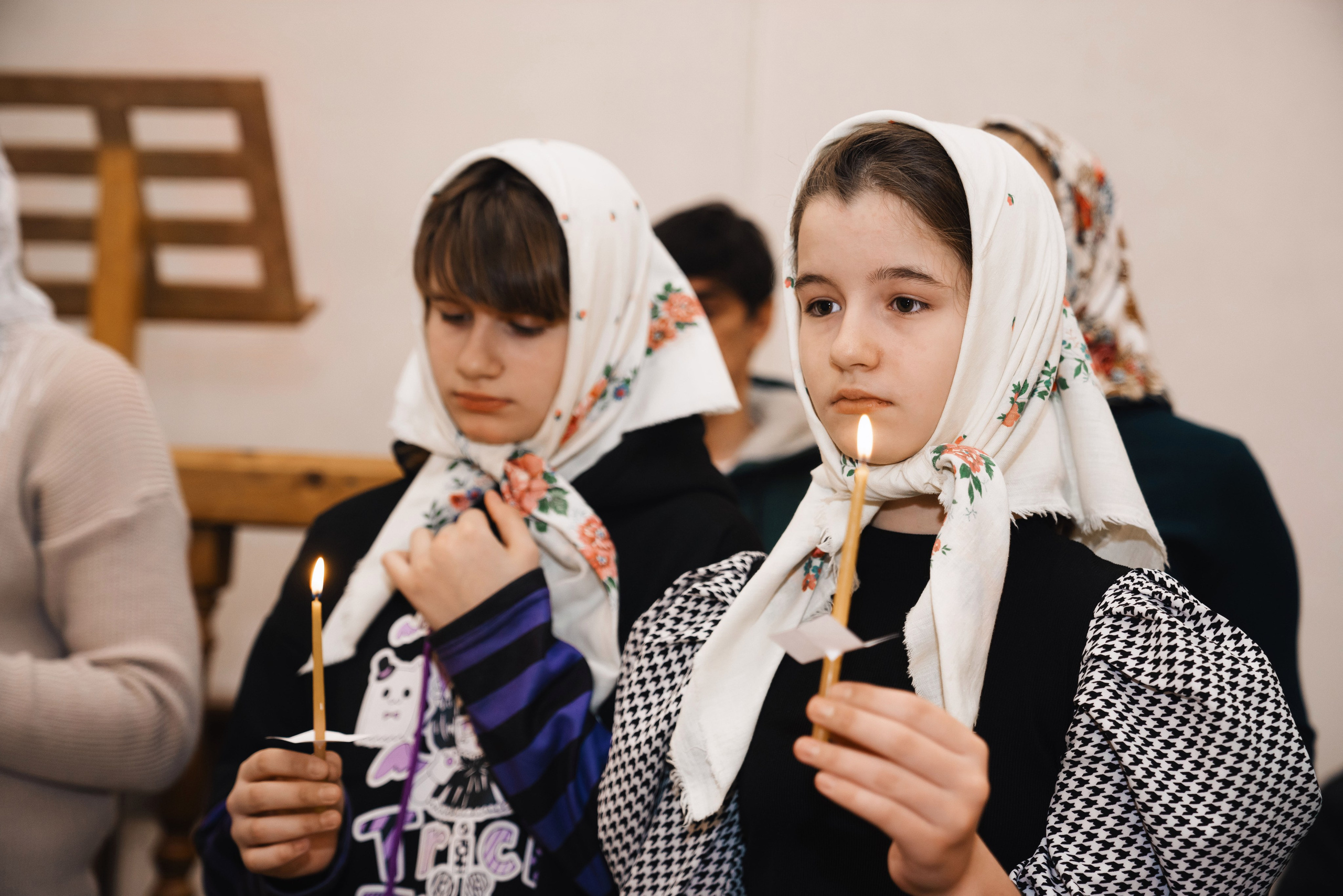 девочки со свечами в храме во время крещения
