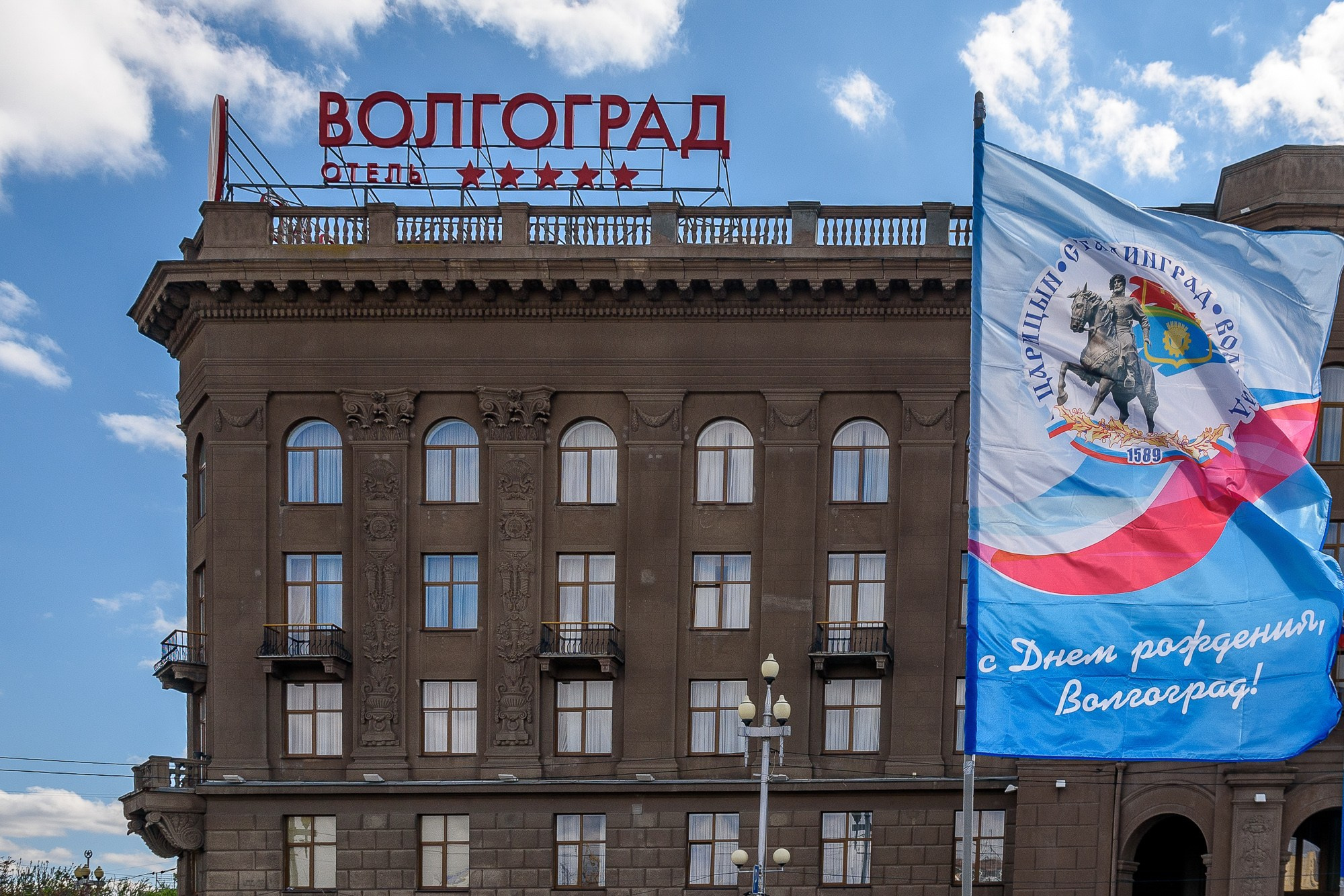 Фасад здания отеля "Волгоград" со знаменем на переднем плане