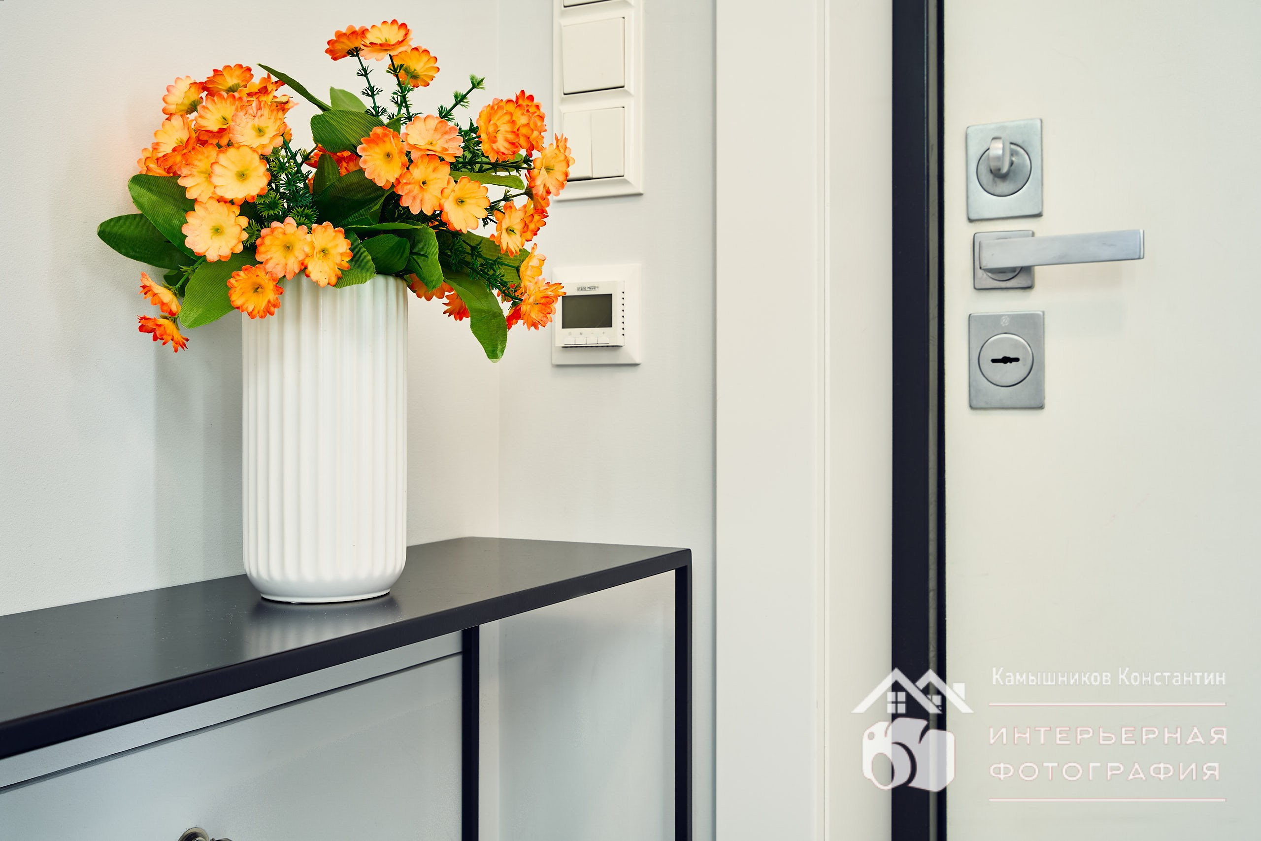 Интерьерное фото. Светлые апартаменты в Москве, прихожая, букет оранжевых цветов, средний план