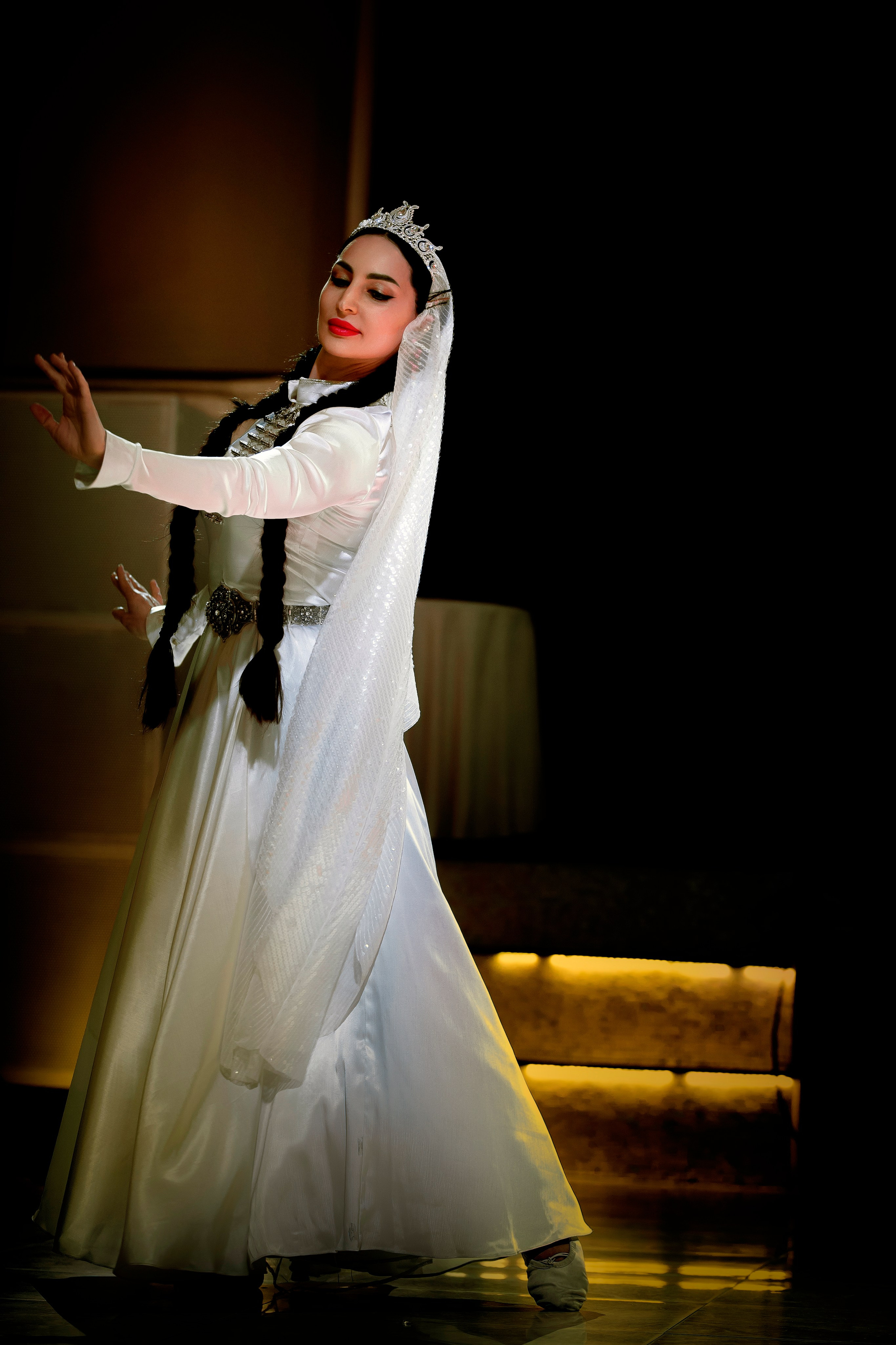 Восточная красавица с лампой Аладдина в развороте уходит с кадра, освещена золотым софитом на ED Fashion Show New Names 2024.