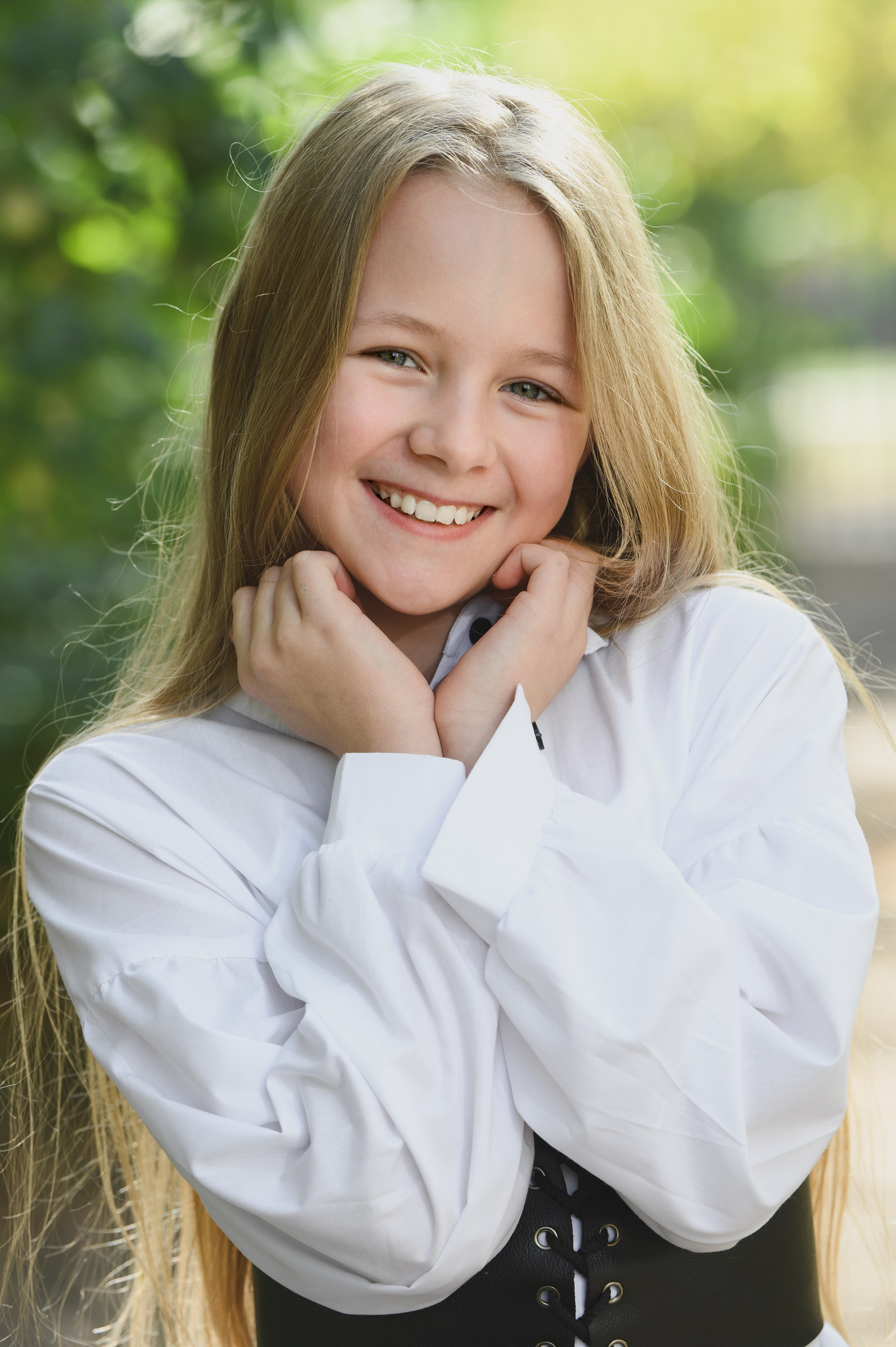 Улыбающаяся девочка с длинными светлыми волосами крупным планом