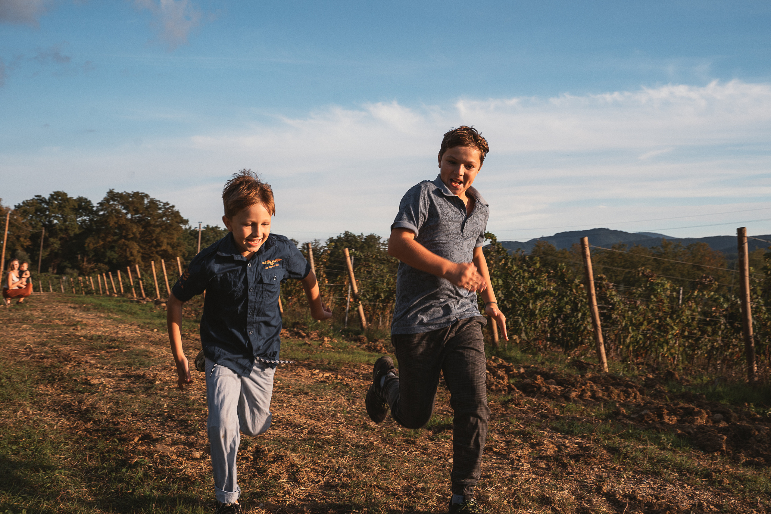 Children run through a vineyard, their laughter filling the air.