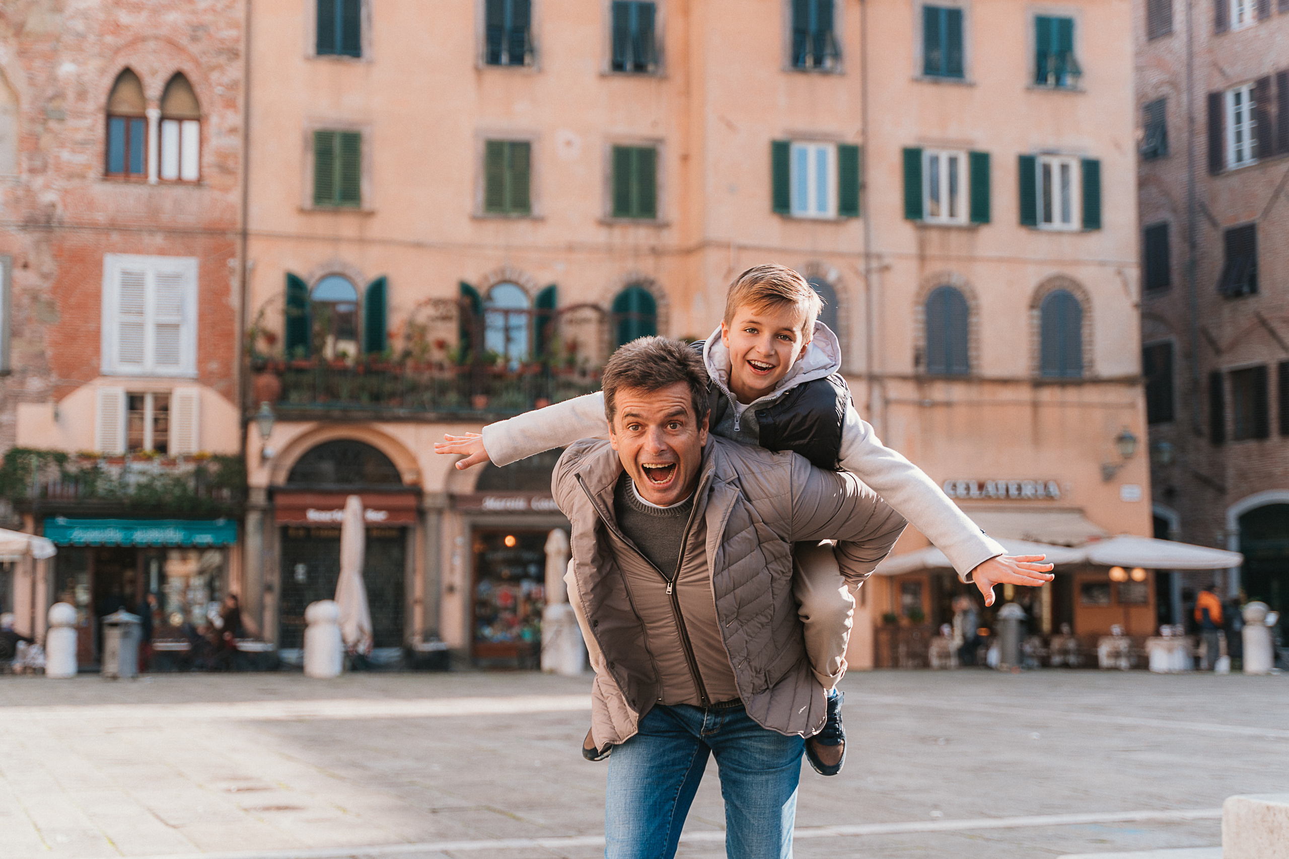 Children playing near the city's ancient walls during a family walk in Lucca.