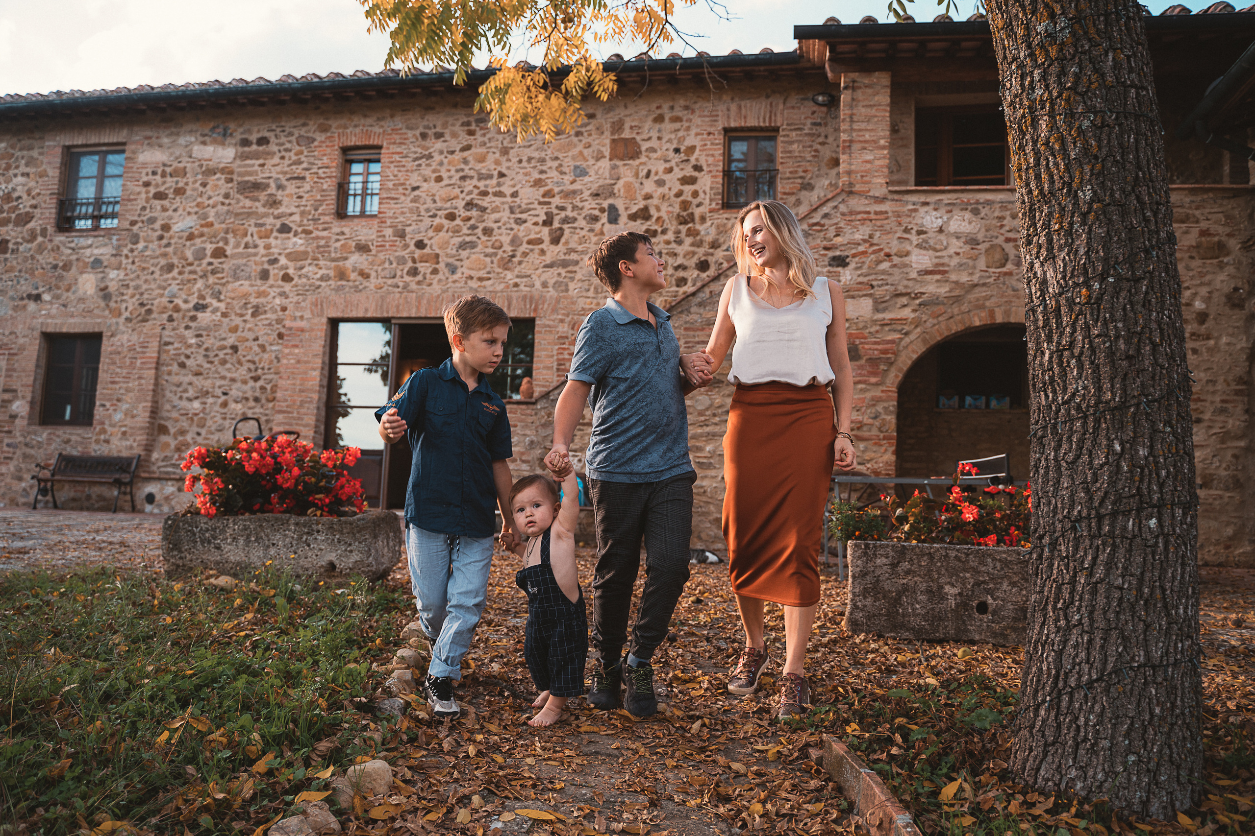 Family walk through a vineyard. A happy family of four smiles under the Tuscan sun.