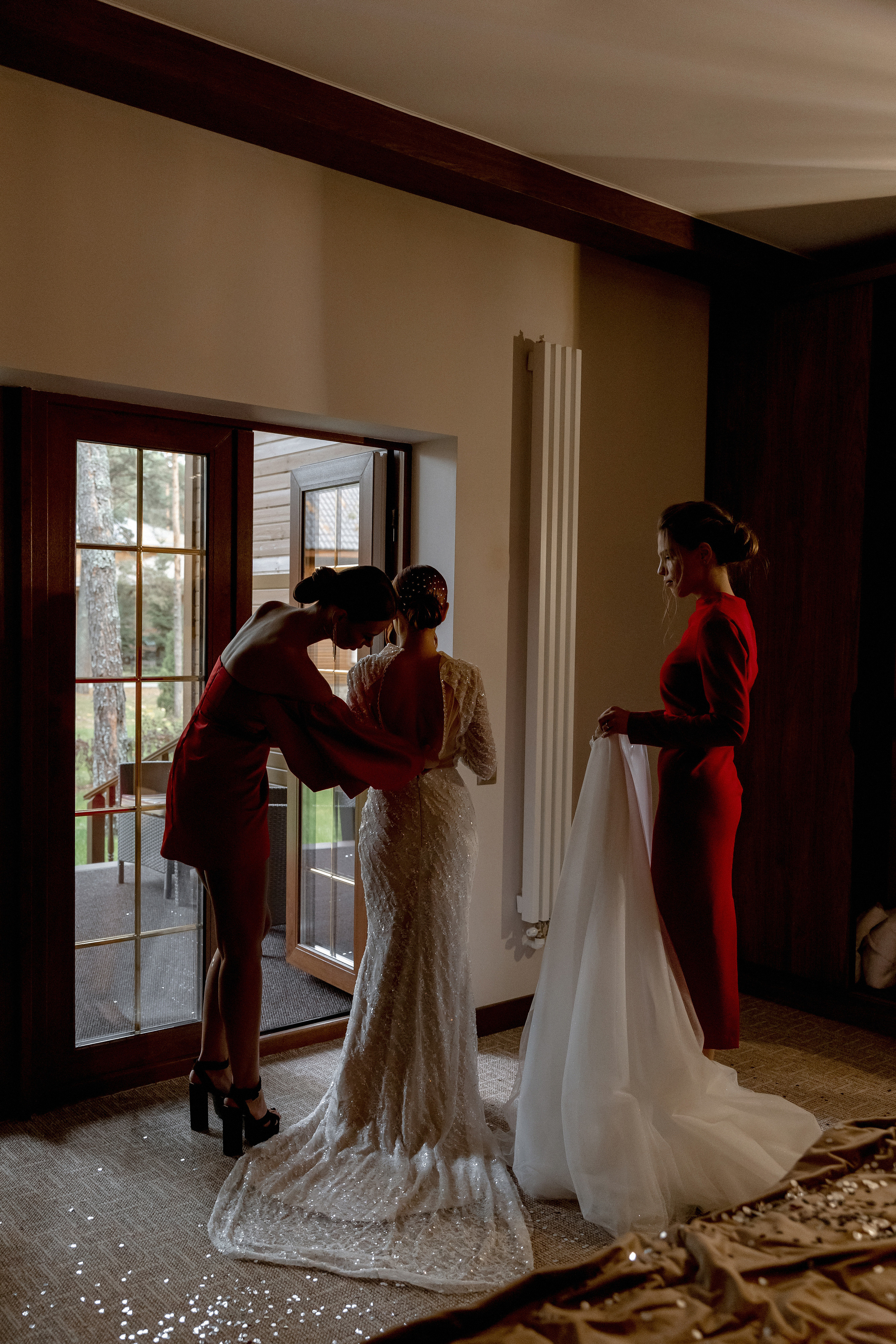 подружки одевают невесту в свадебное платье