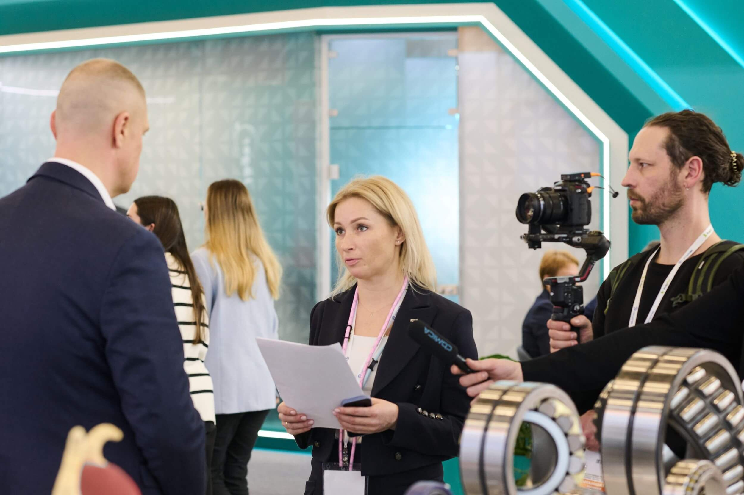 28. Девушка берет интервью у мужчины на выставке.