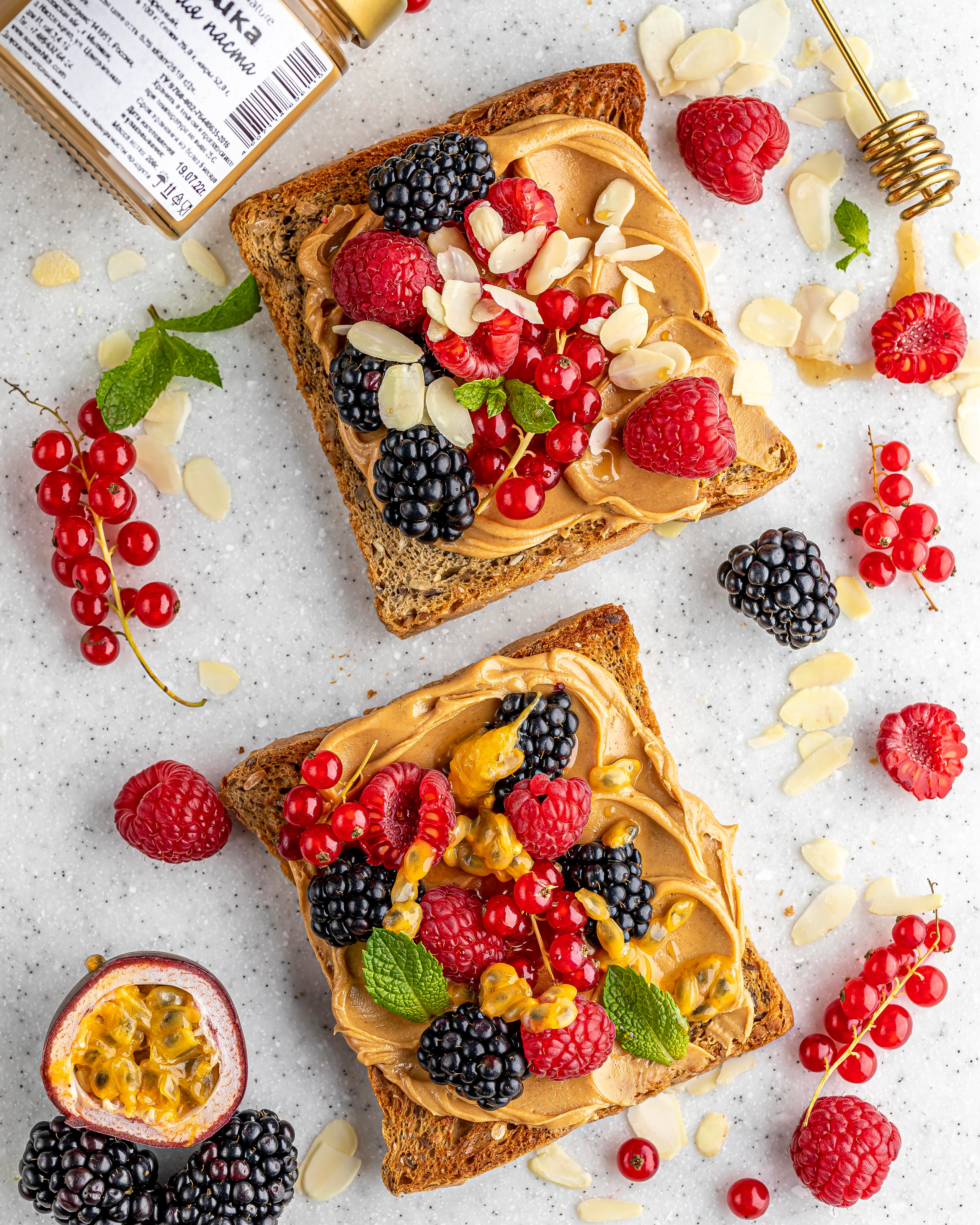 Тосты с арахисовой пастой и свежими ягодами на светлом фоне. Аппетитные продающие кадры.