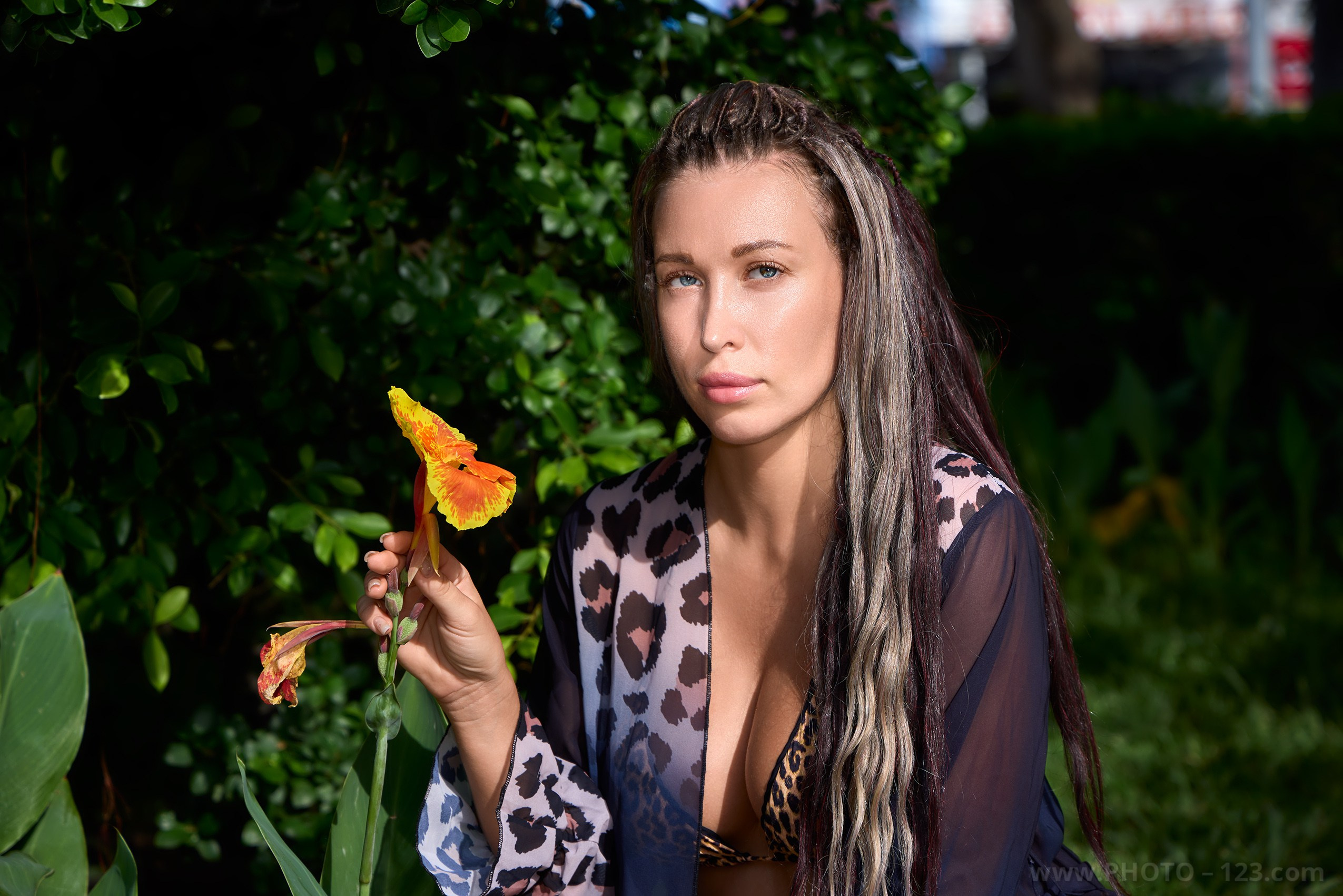 Close up beauty model portrait with an exotic yellow flower shot in natural ambient lighting in Nha Trang.