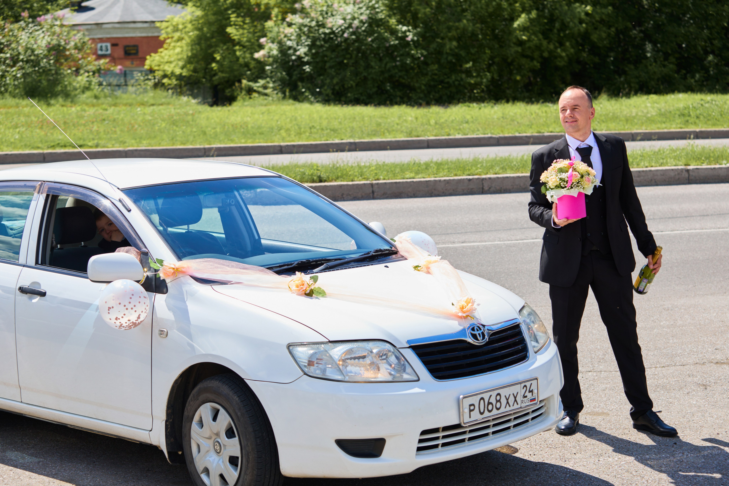 жених с шампанским и цветами возле машины