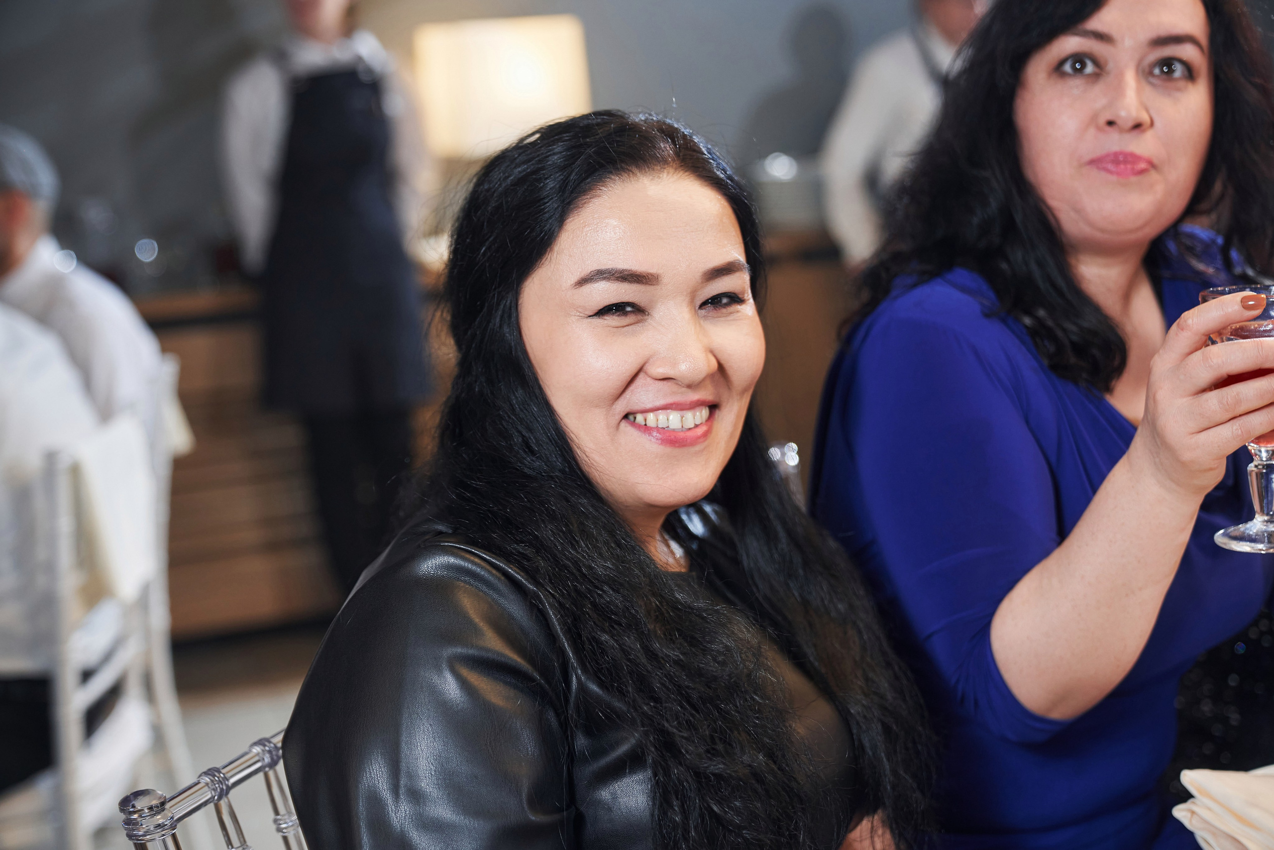 девушка улыбается за праздничным столом в Новый год