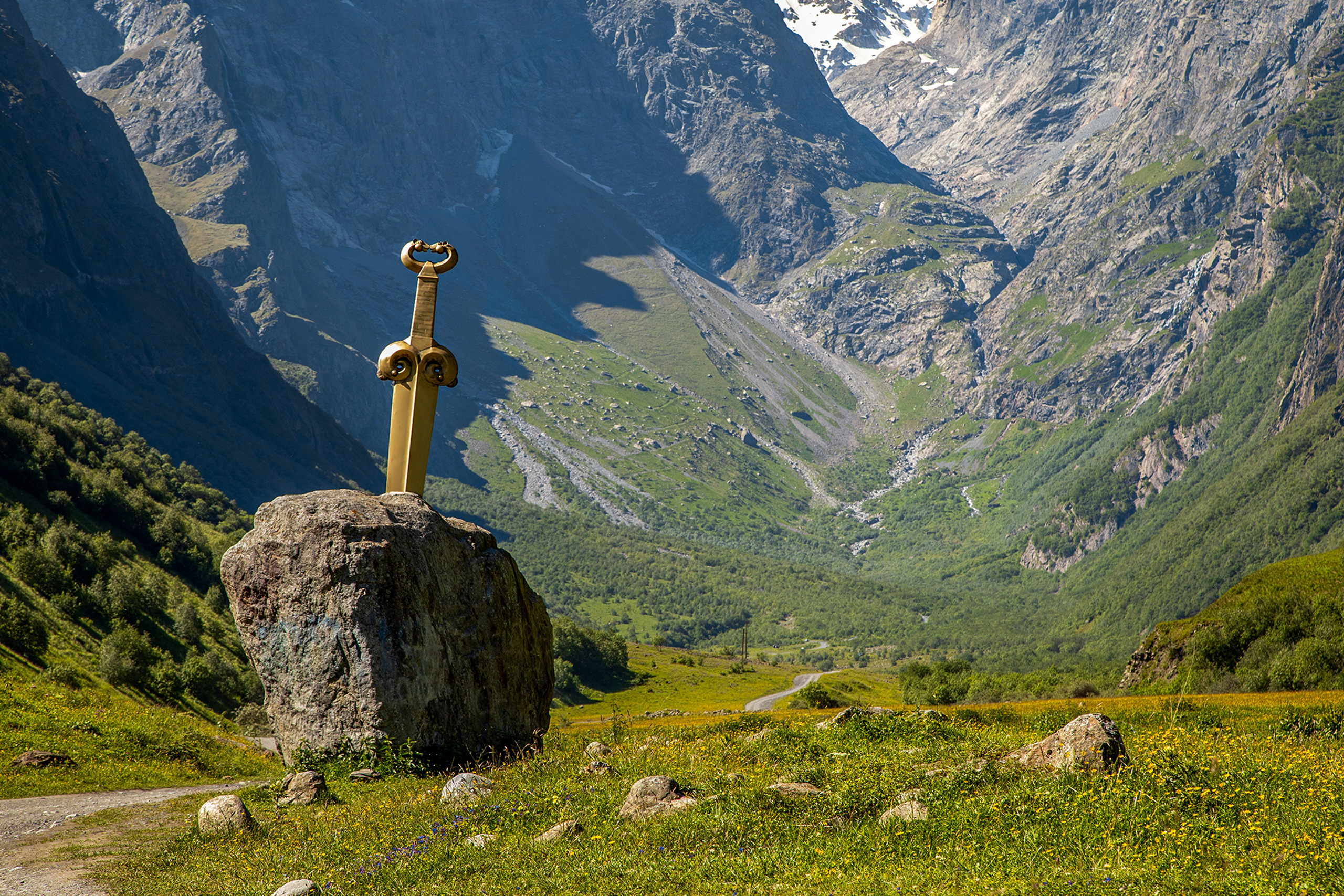 Арт объект Скифский акинак в долине мидаграбинских водопадов, огромный меч в камне на фоне гор