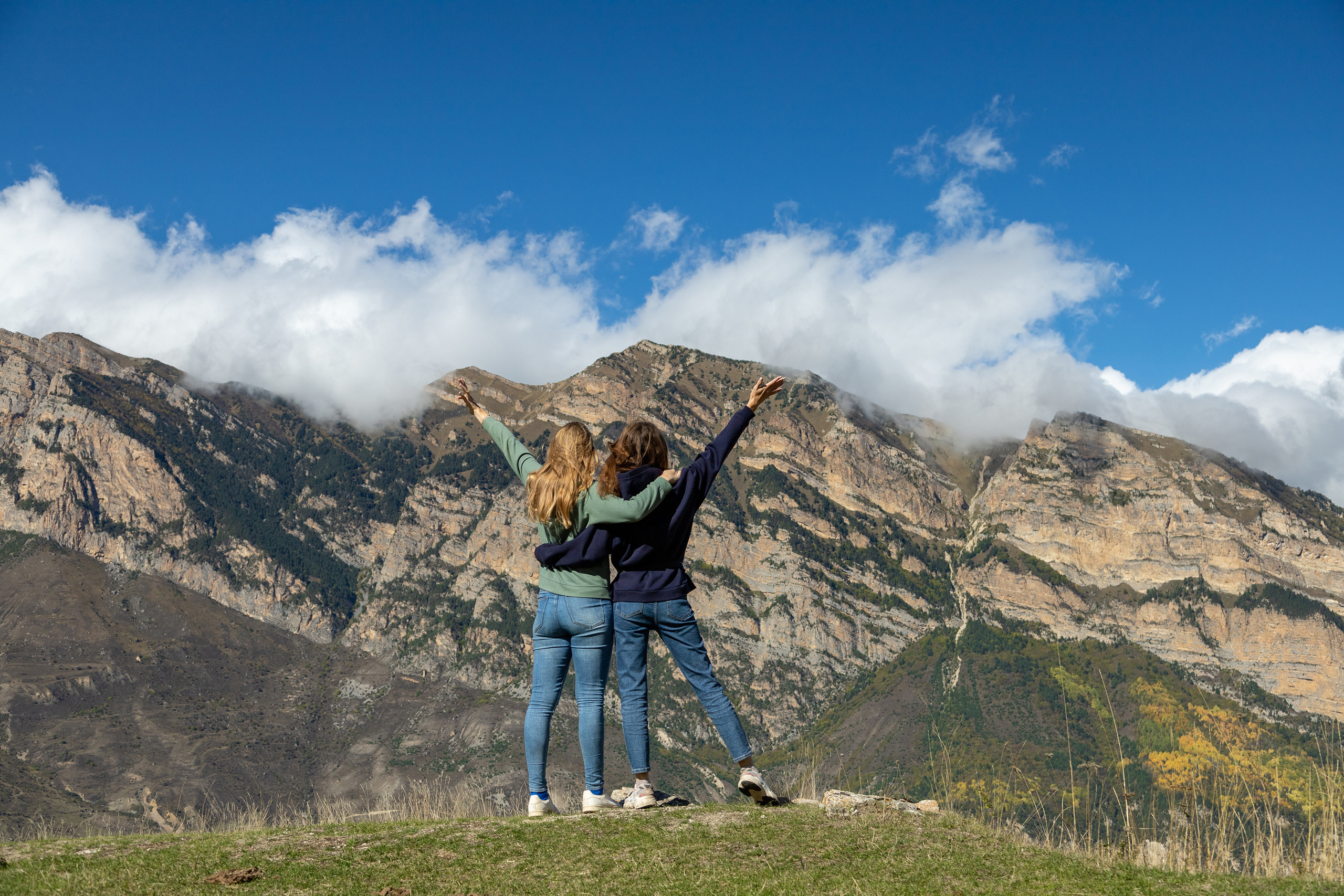 Девушки-туристки на фоне гор Дигорского ущелья около селения Галиат в Осетии, ощущение свободы