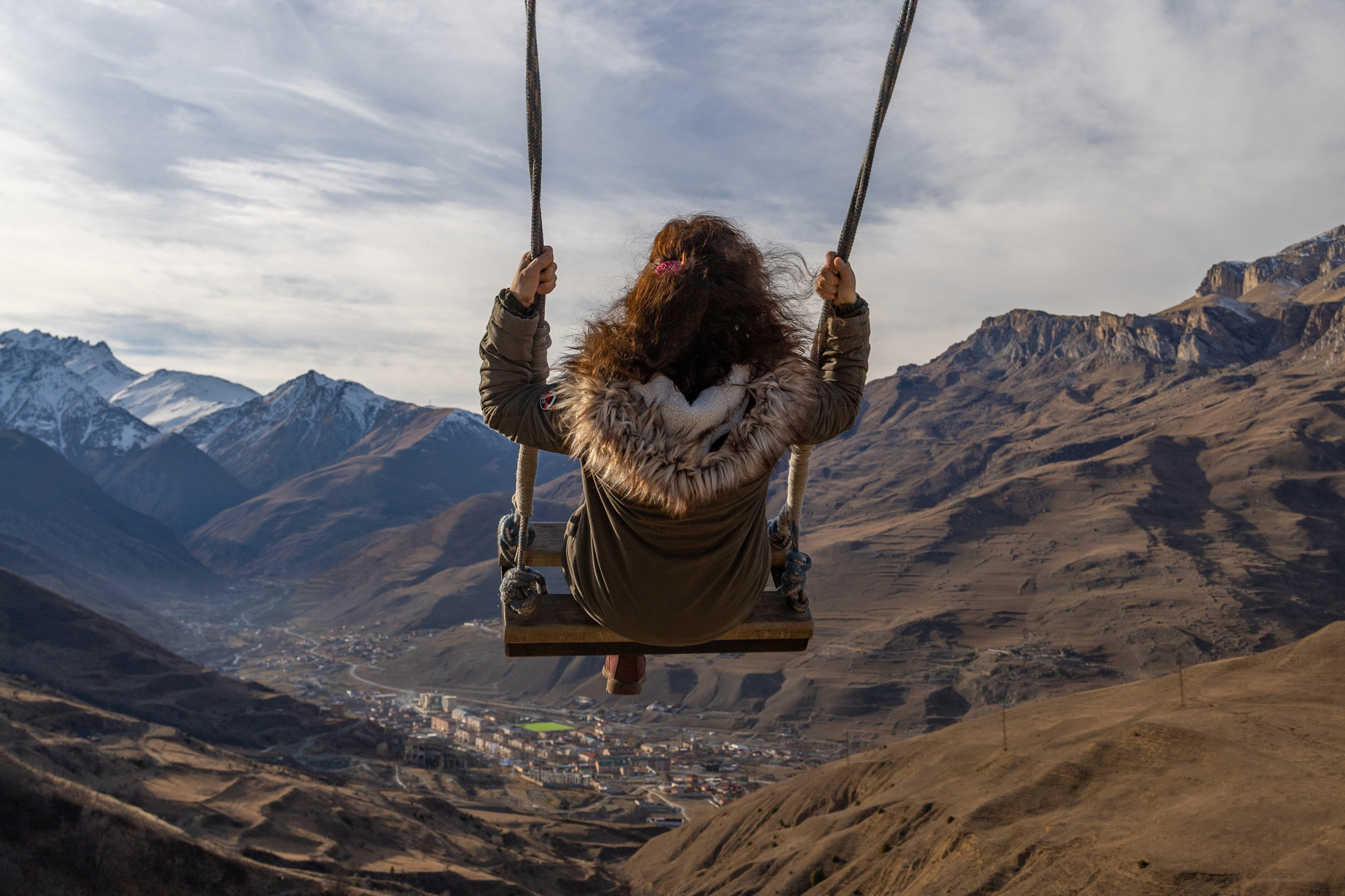 Качель в горах по дороге между Фиагдоном и Даргавсом. Девушка на качели на фоне гор