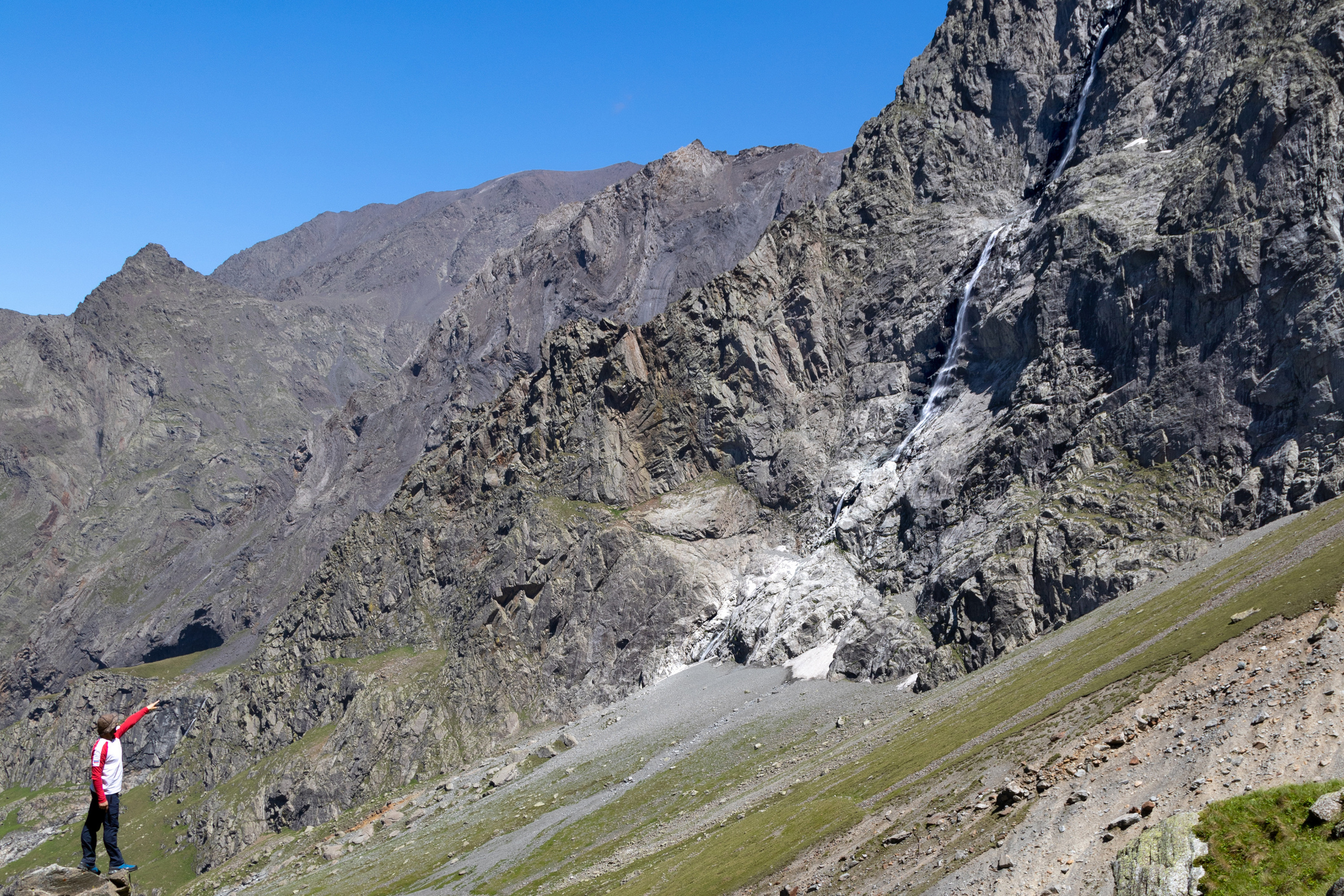 Человек указывает на водопад Большой Зейгалан. Один из самых высоких водопадов в Европе. Долина Мидаграбинских водопадов