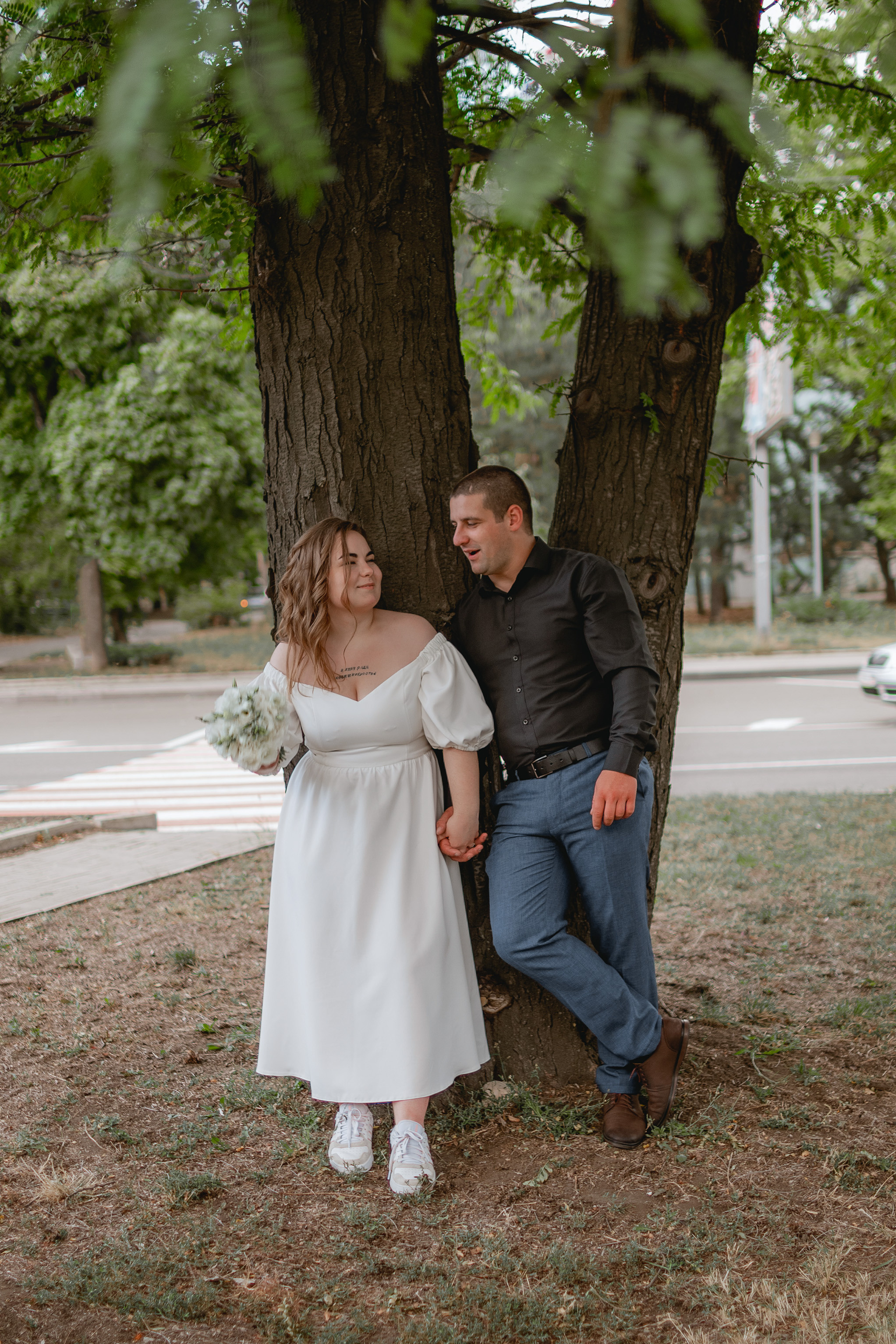 Свадебная фотосессия на улице возле большого дерева