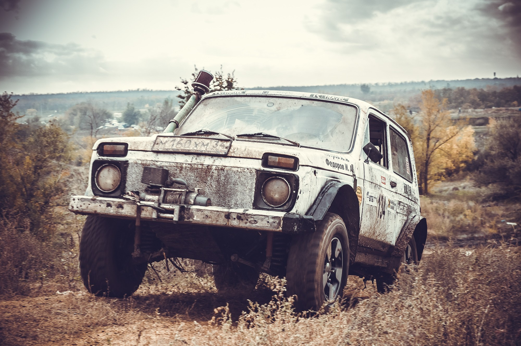 Автомобиль Нива заезжает на холм
