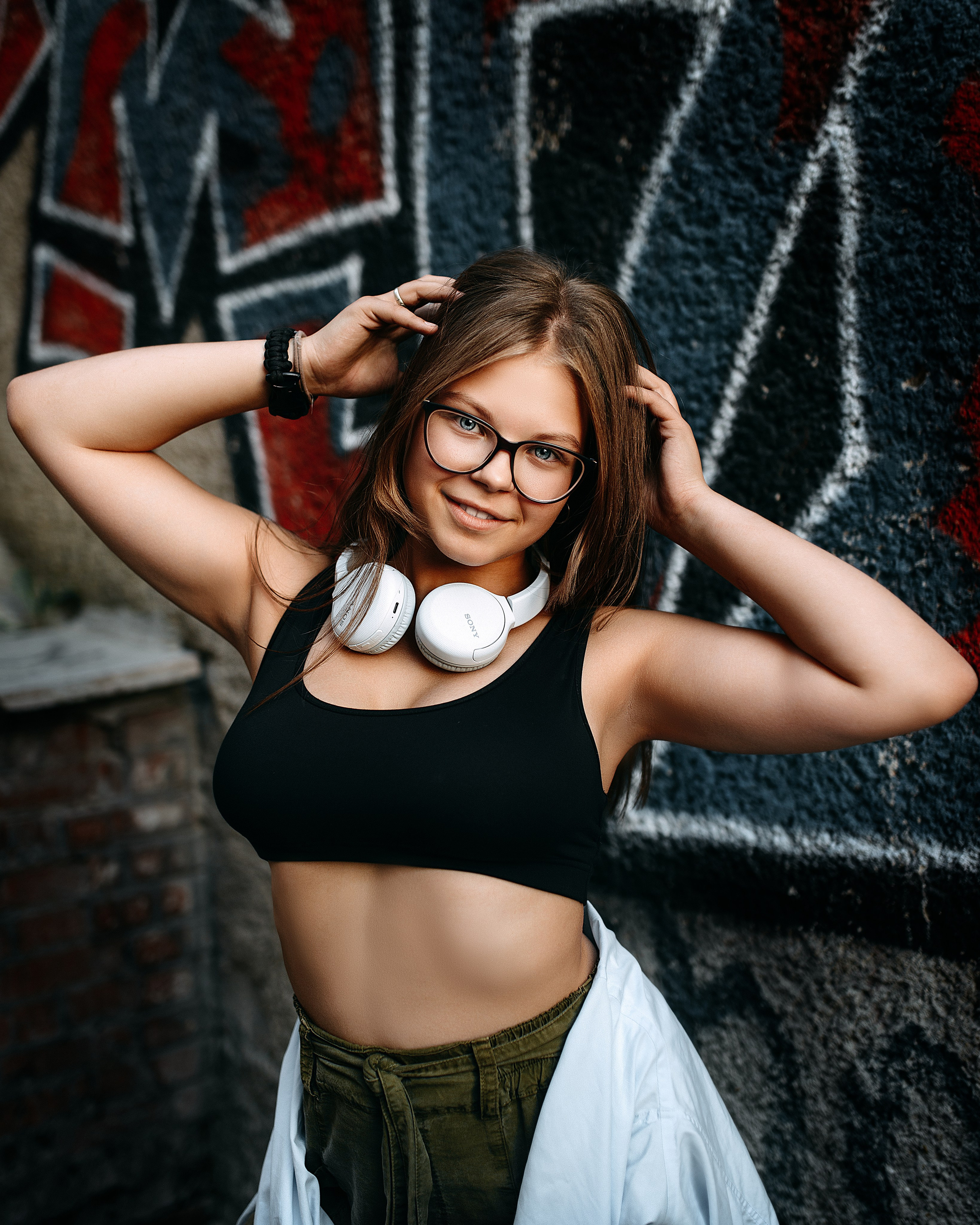 Портрет девочки в очках и наушниках, стильная подростковая фотосессия у граффити