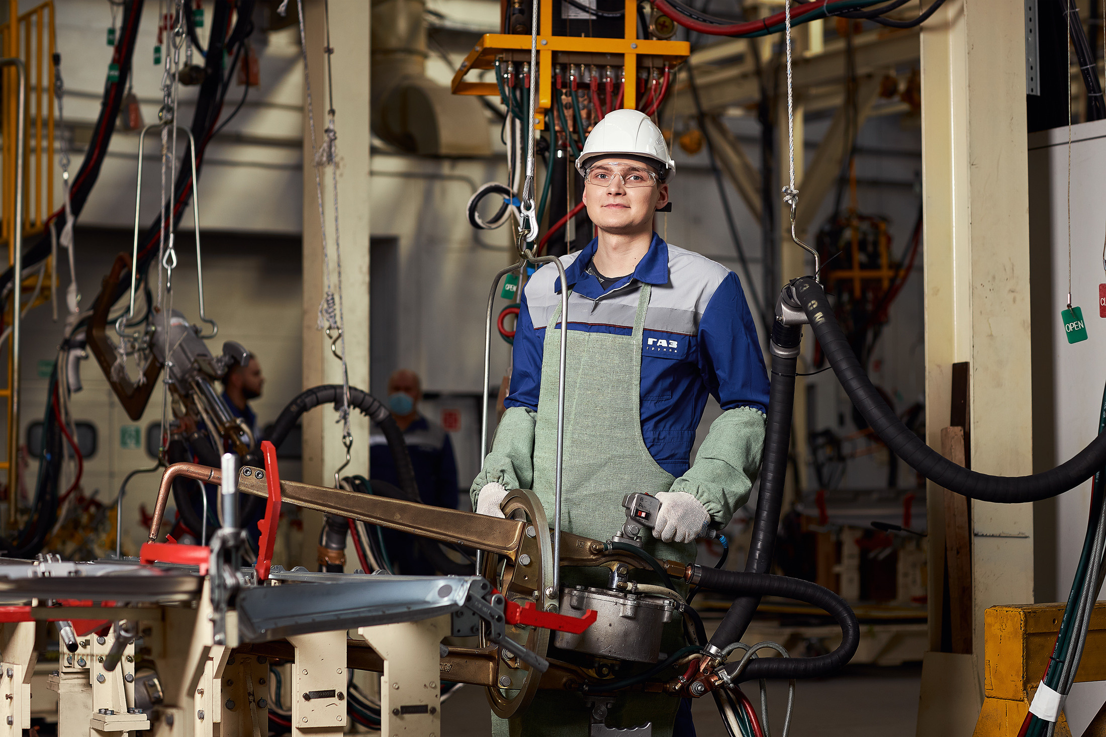 Рабочий держит в руках манипулятор прибора для сварки металлических поверхностей.