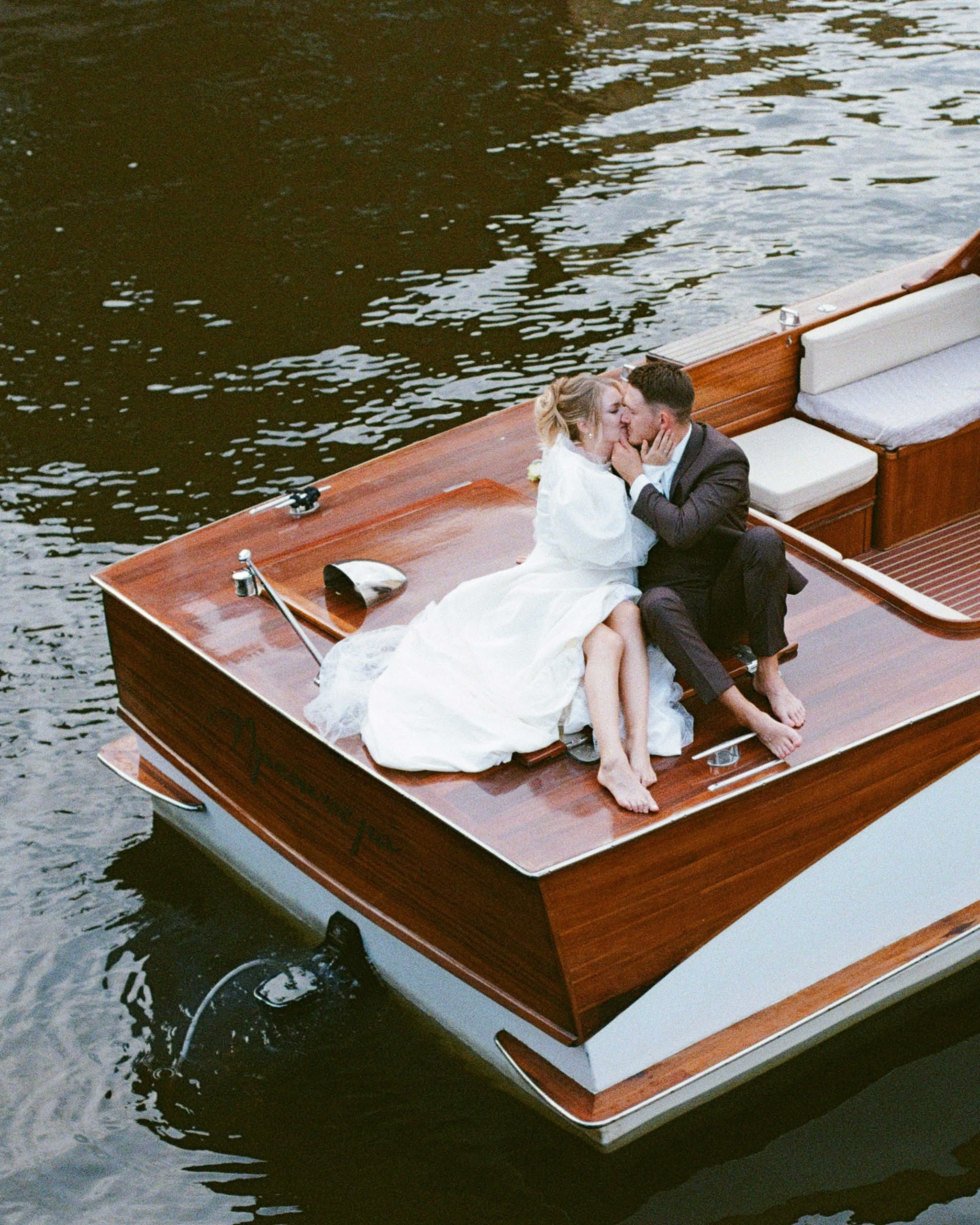 Плёночный кадр: пара на катере во время свадебной прогулки по Неве