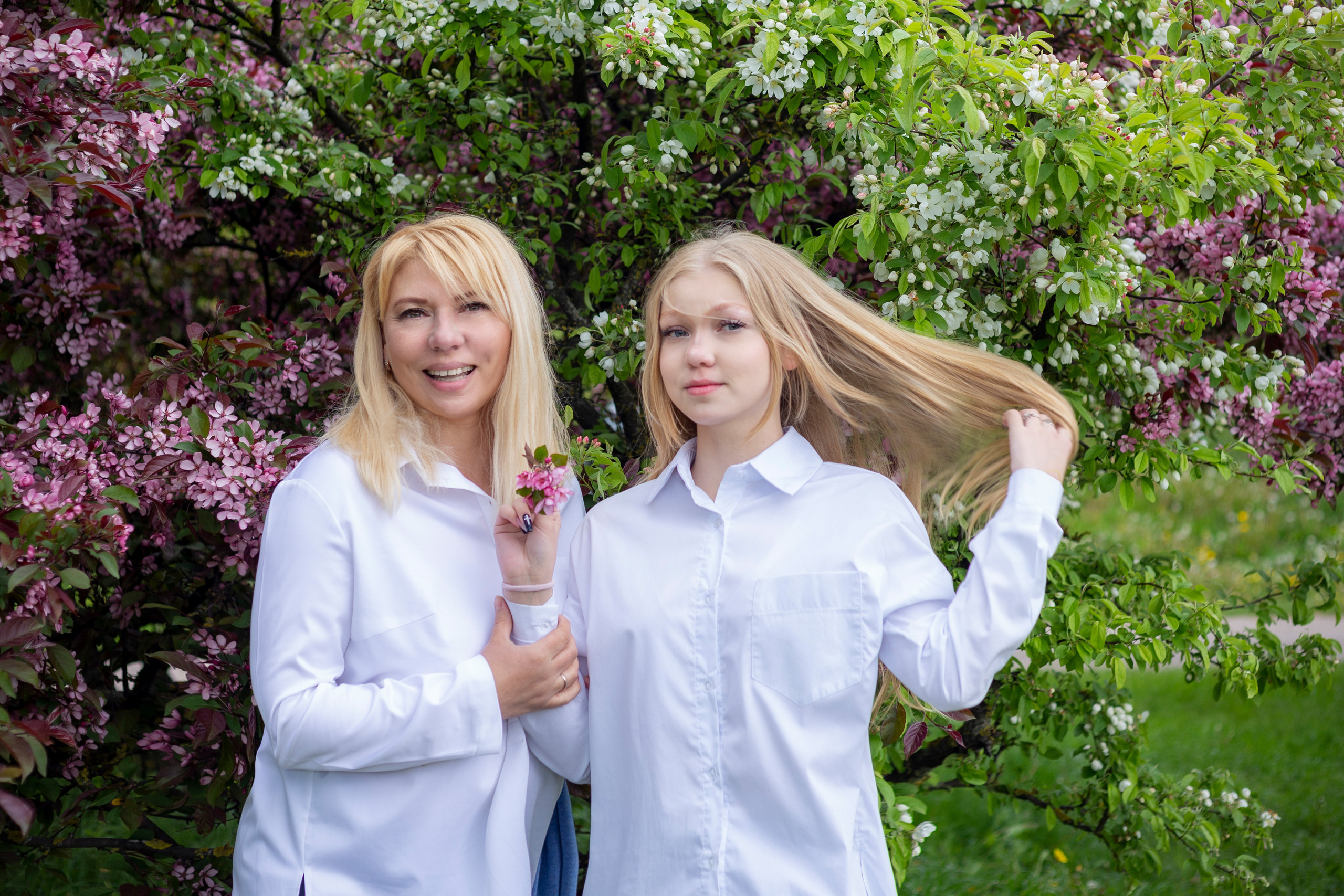 Мама и дочь, блондинки, на фоне цветущих деревьев, Минск