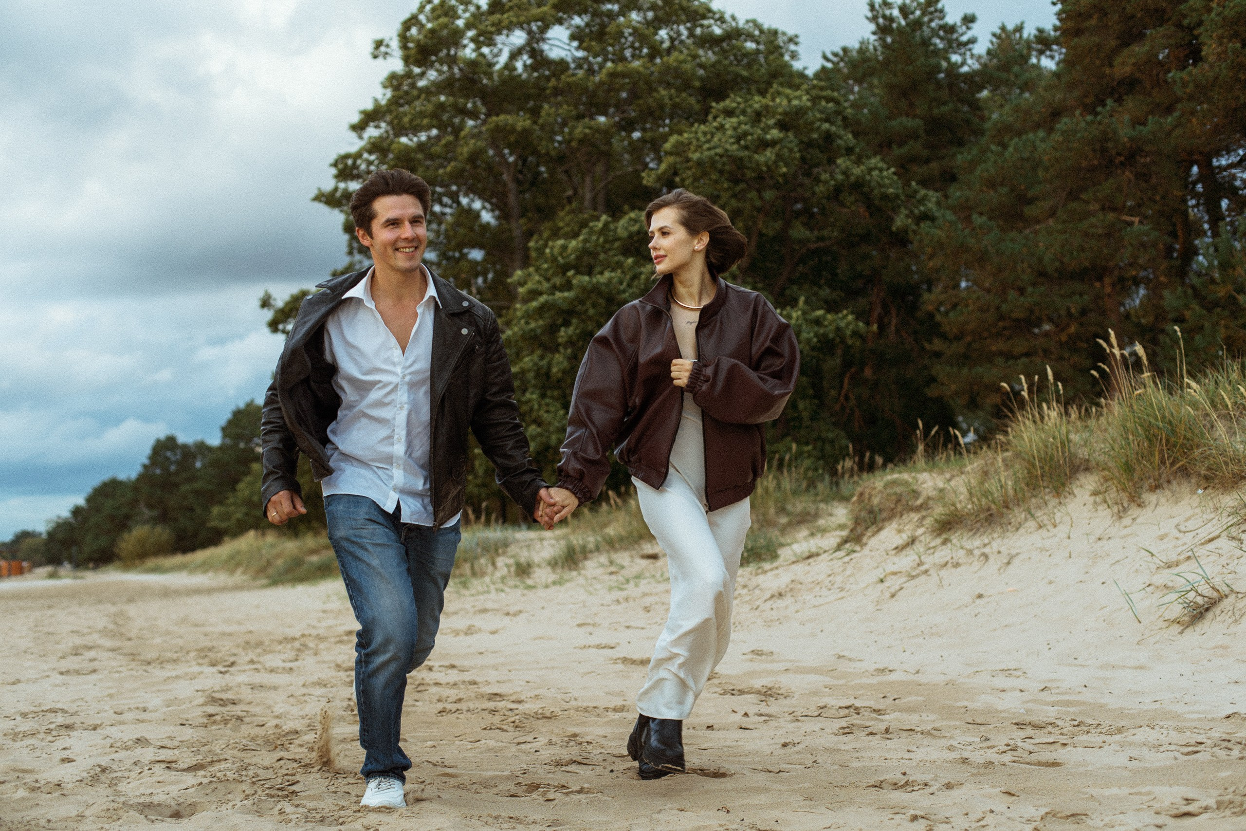 Девушка и парень бегут по песчаной тропе — Love Story у Финского залива