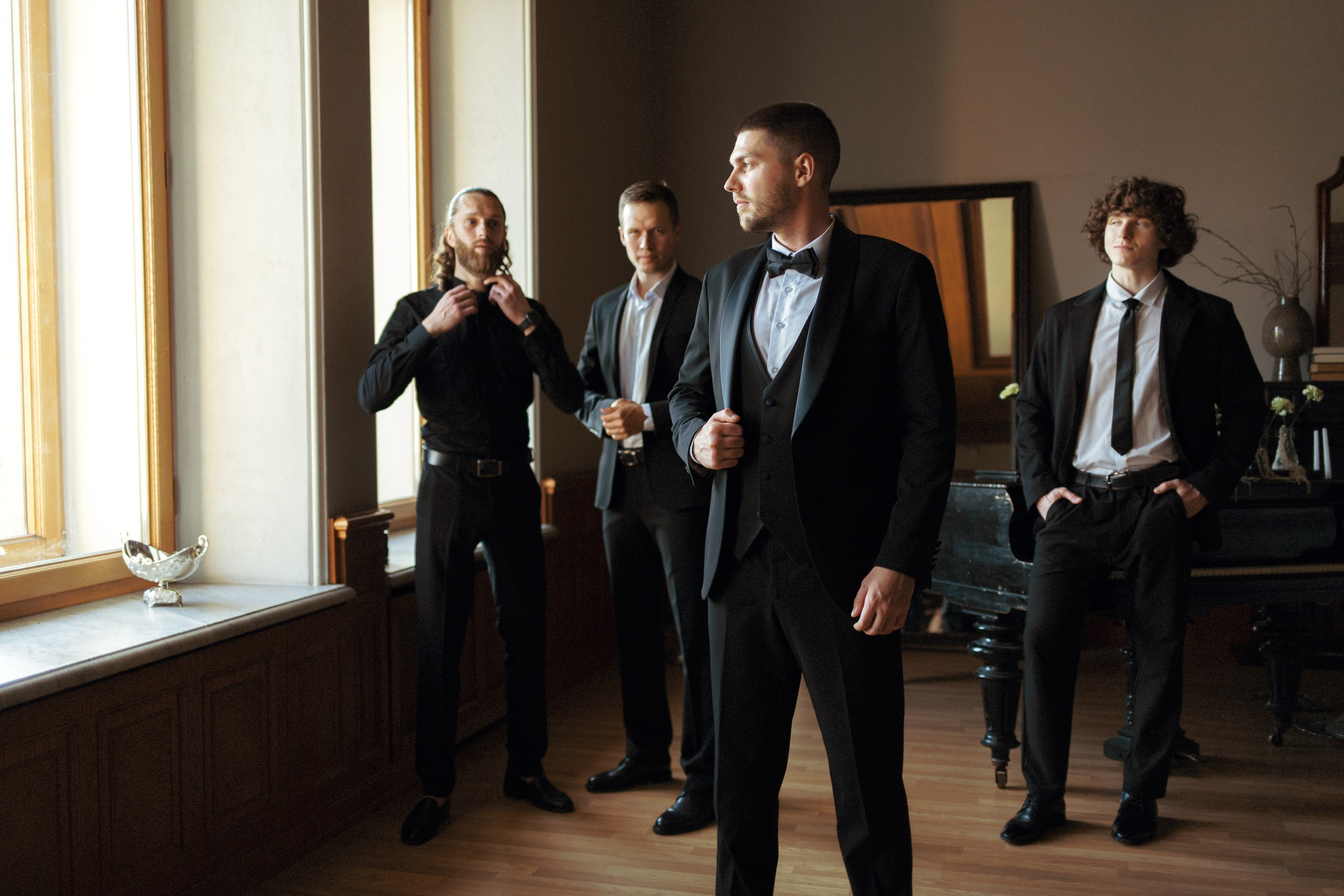 Мужская компания в классических костюмах у окна — свадебная фотосессия в Петербурге