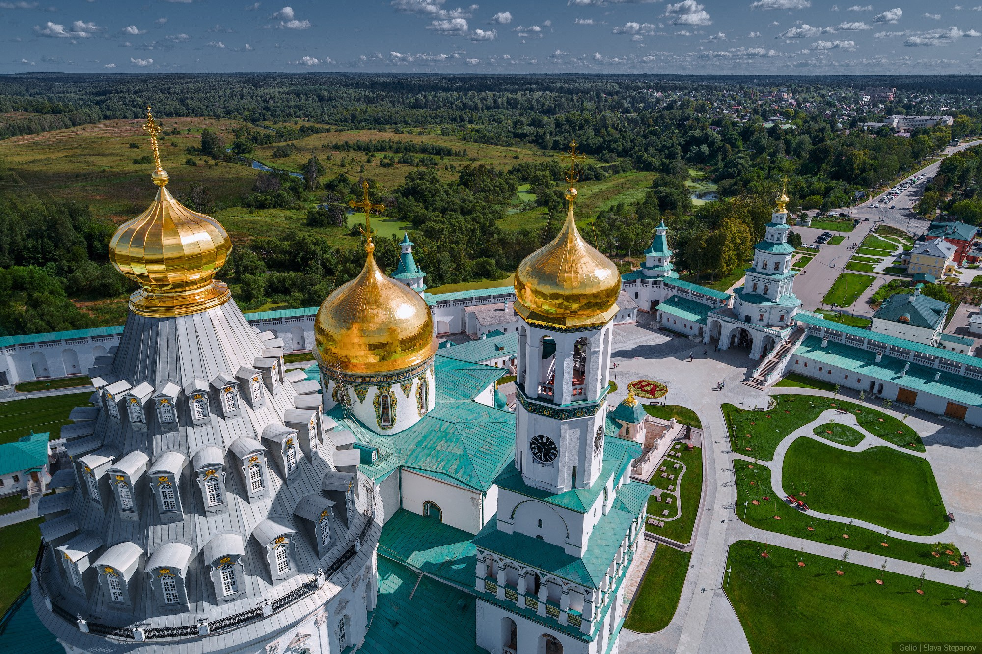 Large-scale temple complex from above — Resurrection New Jerusalem Monastery. Golden domes and green roofs against a summer landscape. Aerial photography, Gelio.